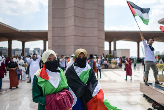 متظاهرات ماليزيات يحملن أعلام فلسطين