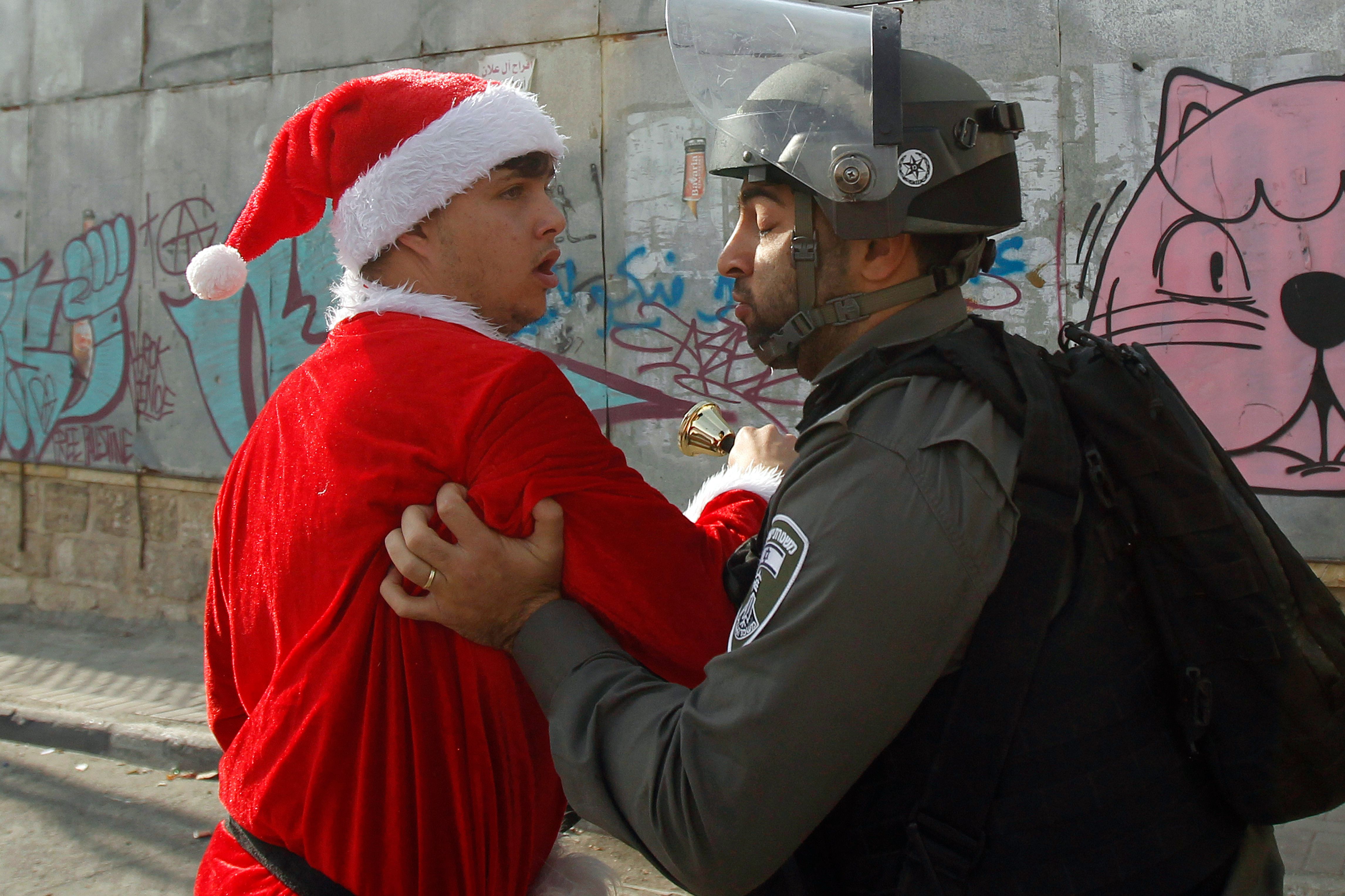 أحد عناصر الاحتلال يدفع شاب فلسطينى