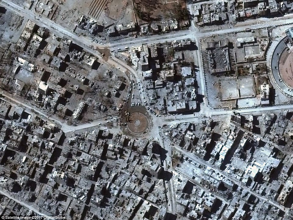 القوات السورية في ساحة النعيم الشهيرة في الرقة محاطة بأطلال المباني المدمرة