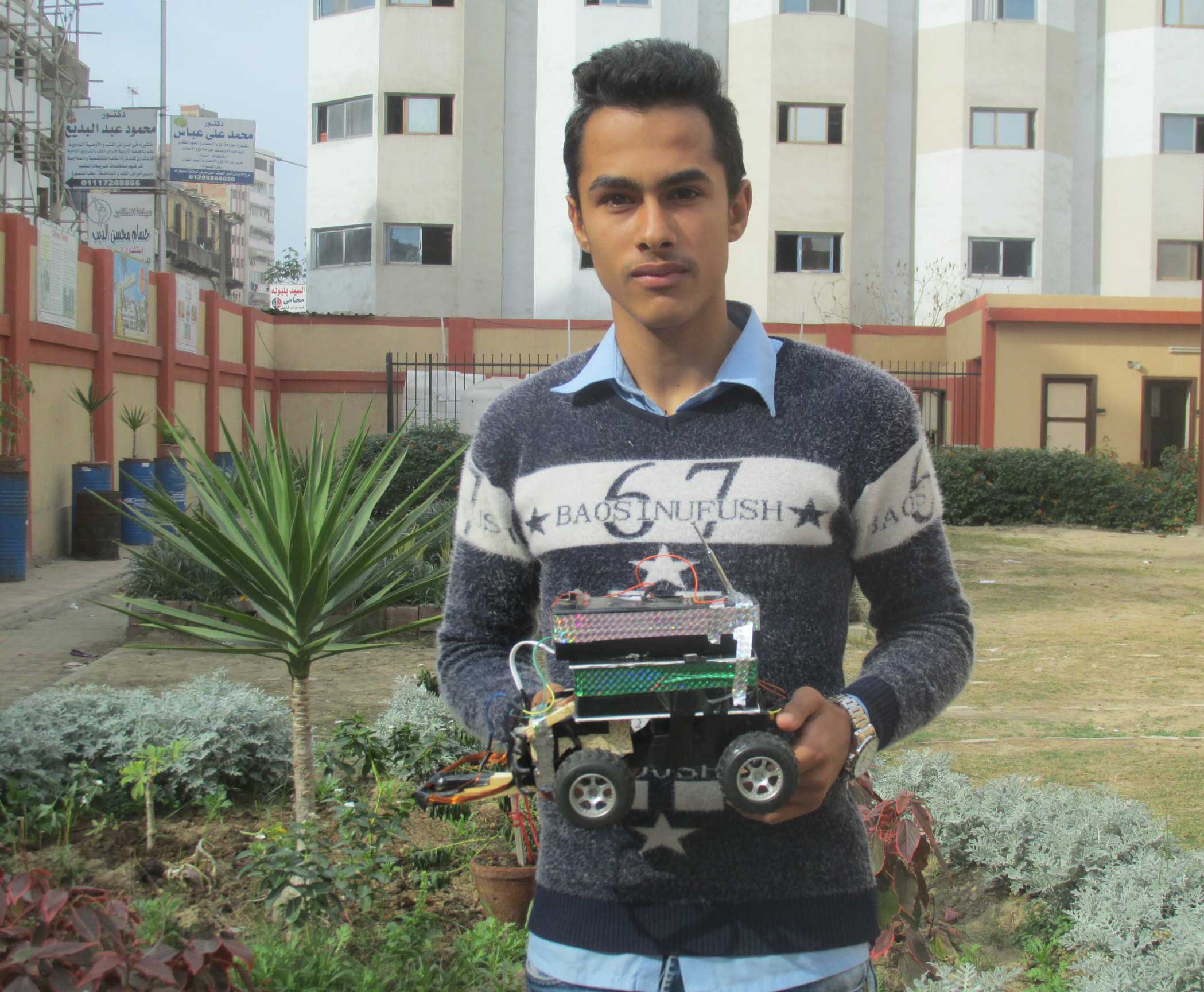 الطالب سليمان حميدان يحمل سيارة الكشف عن الألغام
