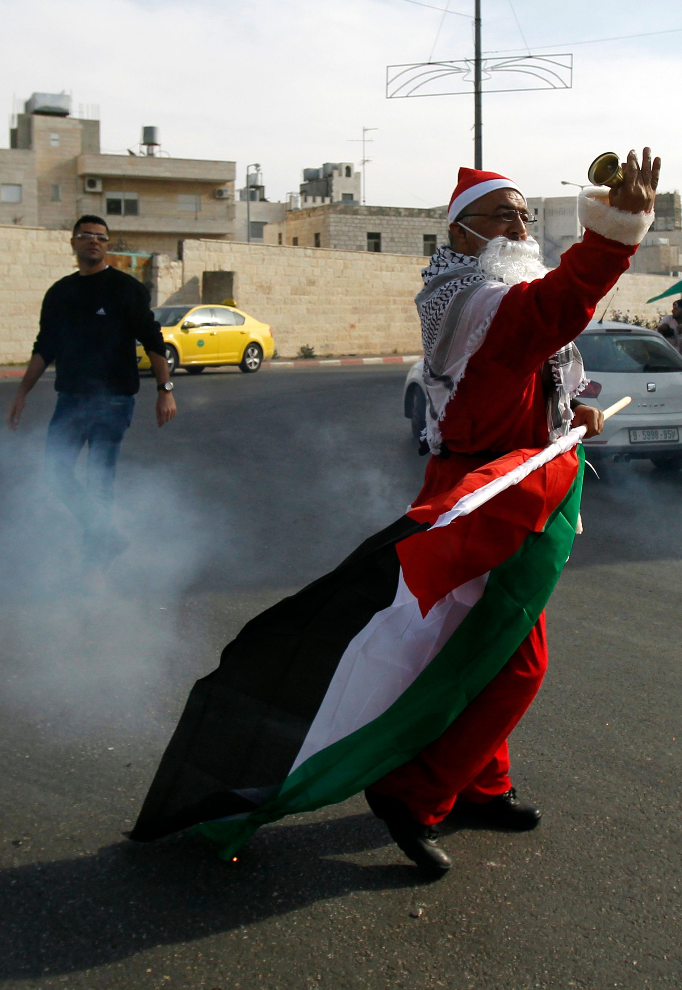 فلسطينى بملابس البابا نويل وسط الدخان المسيل للدموع