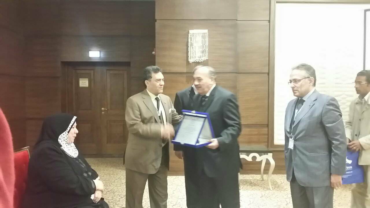 والد أحد الشهداء يتسلم درع التكريم من رئيس جامعة الأزهر