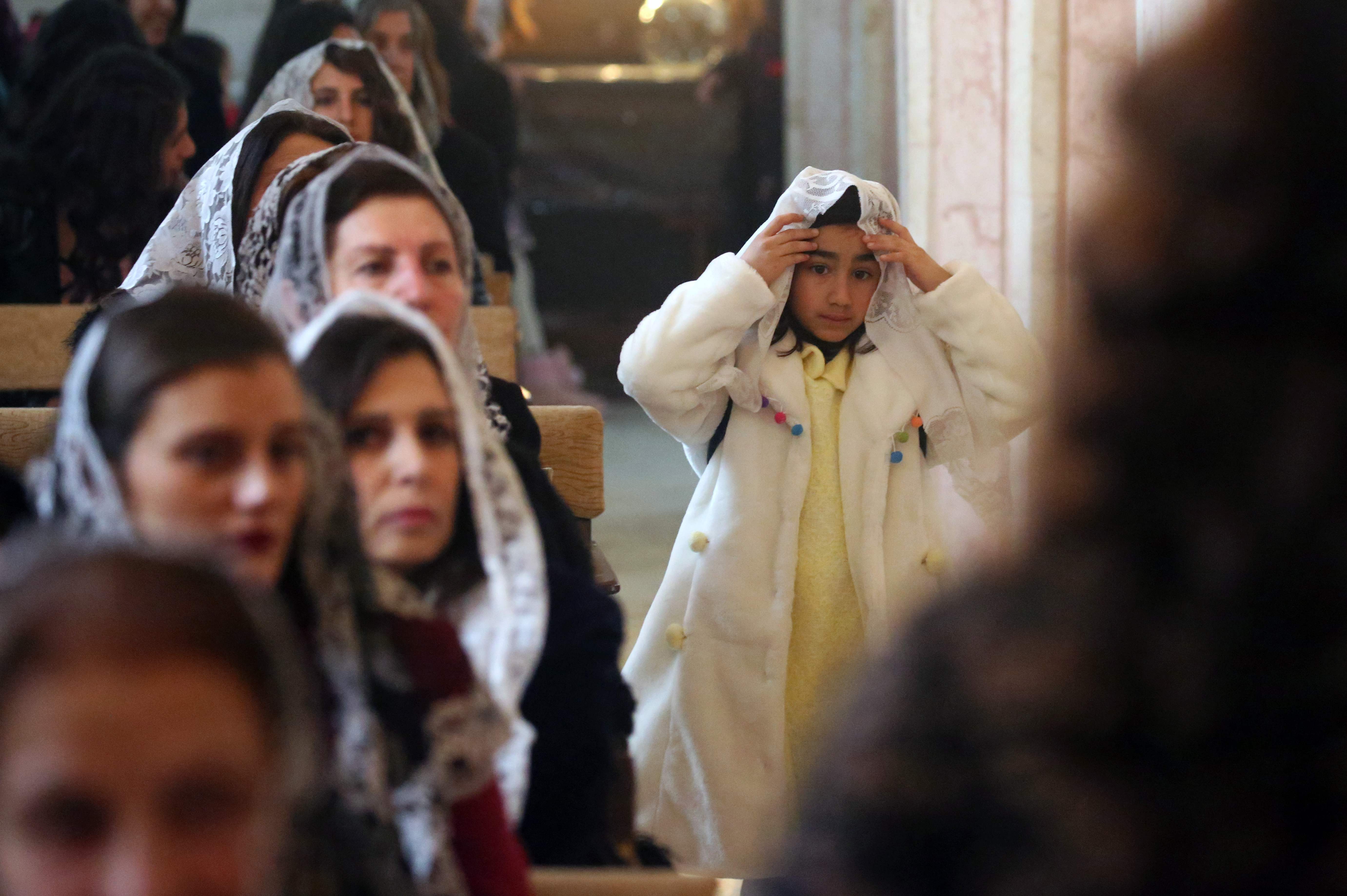 طفلة سورية خلال قداس عيد الميلاد بالكنيسة السريانية الأرثوذكسية مار دودو