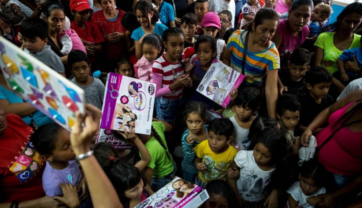 احد  المتطوعين فى توزيع الهادايا على الاطفال الفنزويليين فى عيد الميلاد