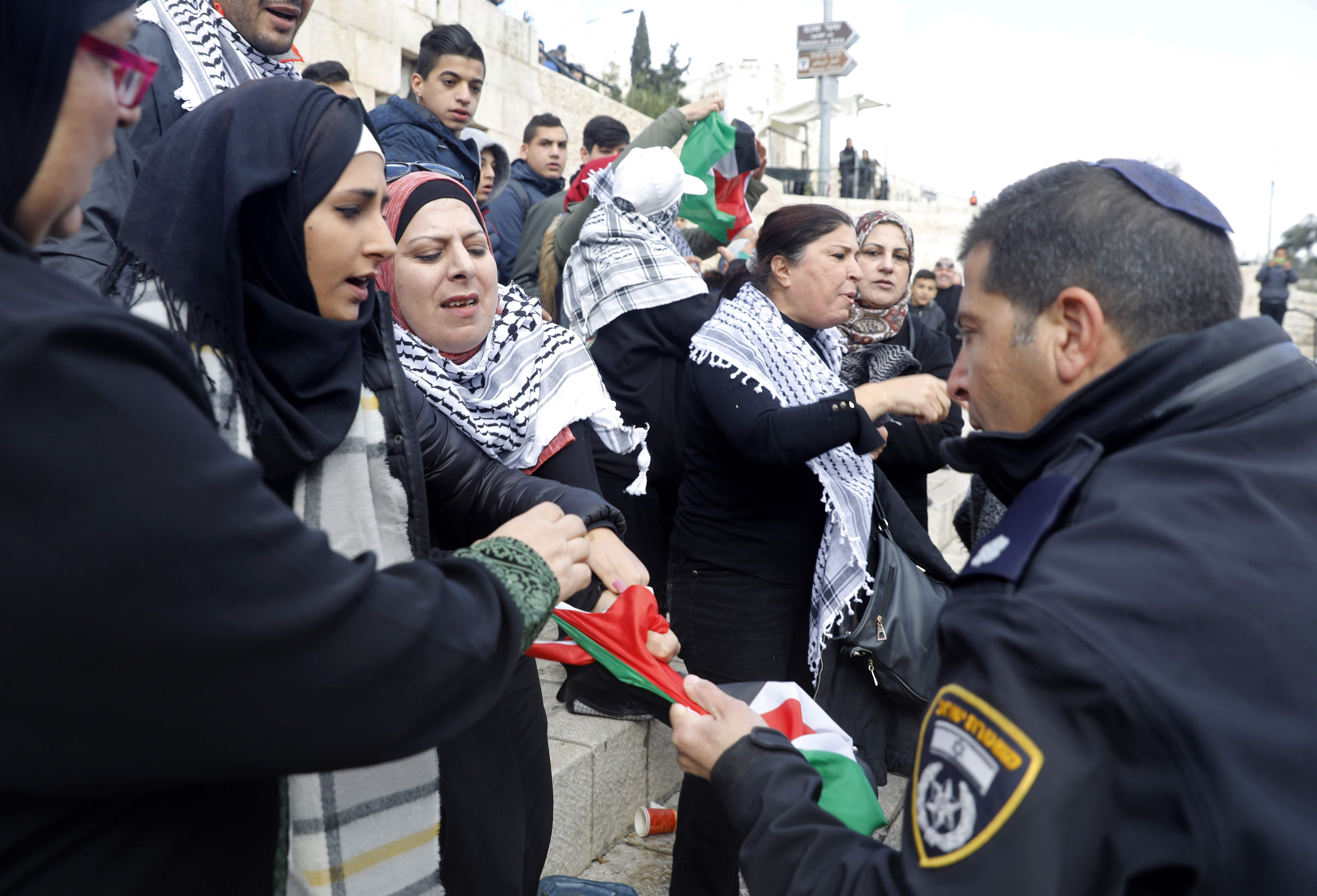 1072159-أحد-جنود-الاحتلال-يحاول-الاستيلاء-من-سيدة-فلسطينية-على-العلم-الفلسطينى