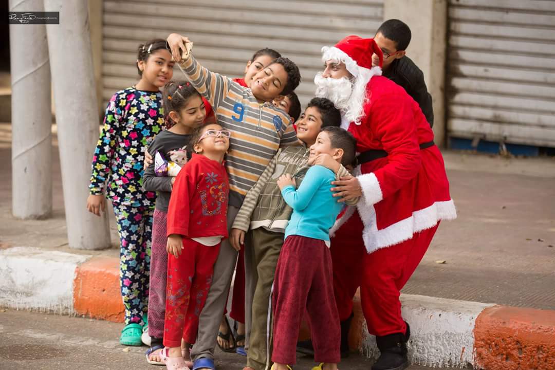 بابا نويل يلتقط سيلفى مع الأطفال