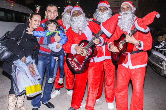 المواطنين يلتقطون صورا تذكارية مع فريق بابا نويل