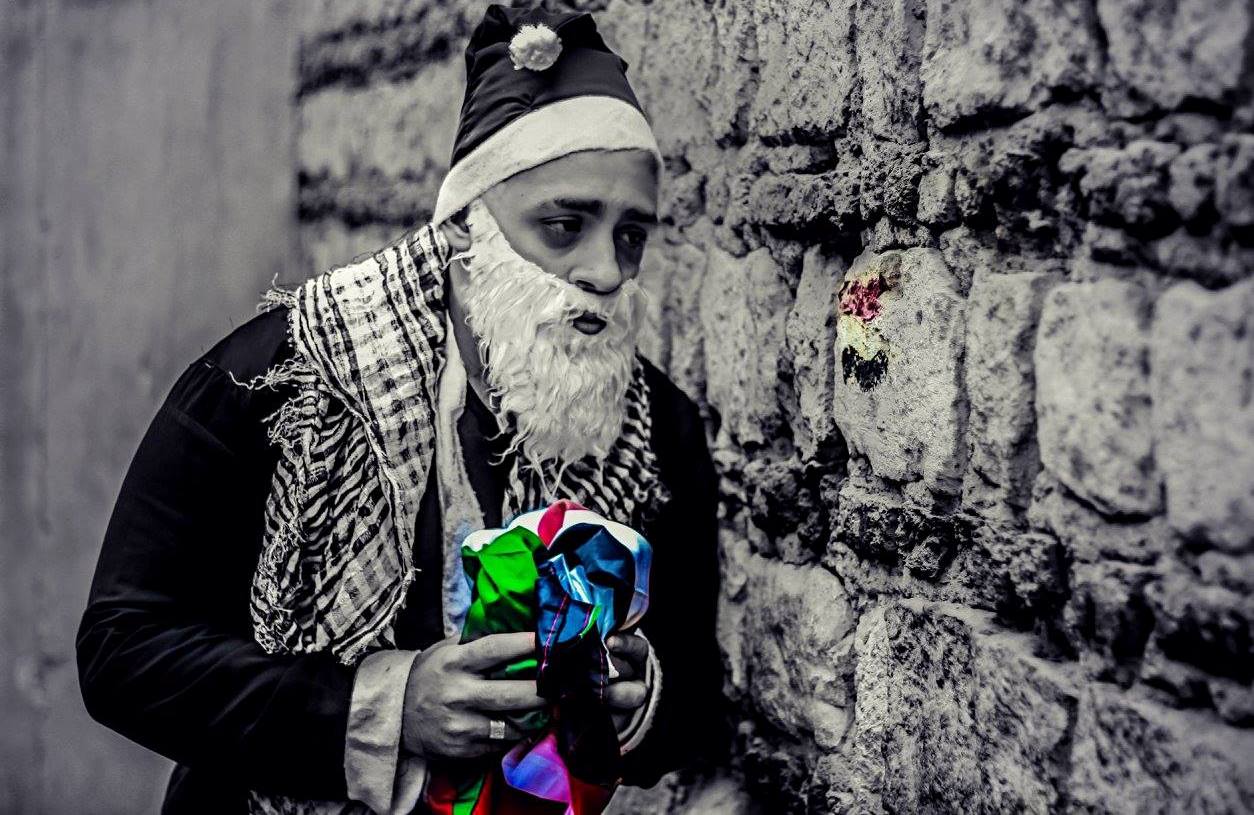بابا نويل يمسك بعلم مصر وفلسطين