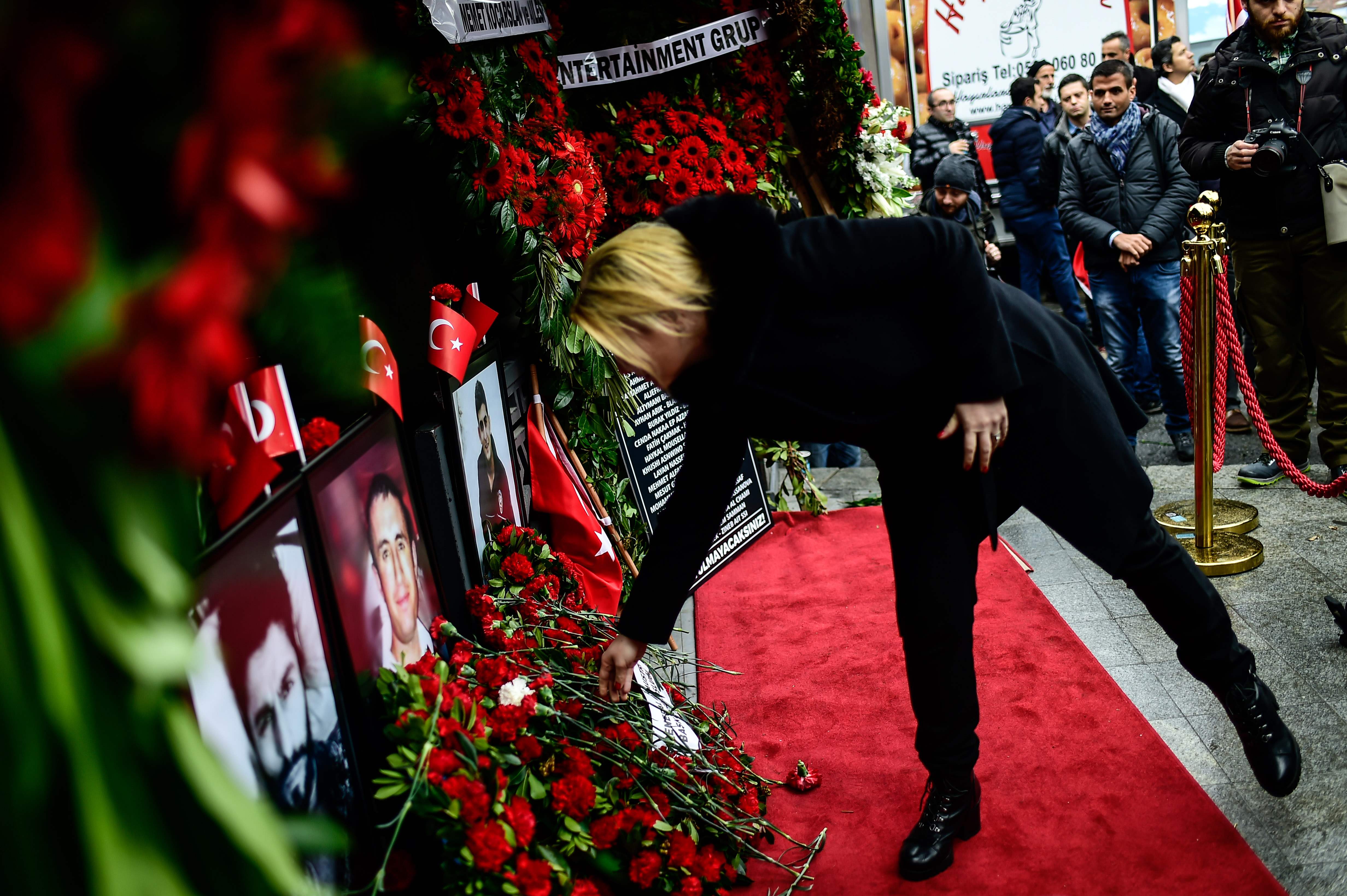 سيدة تضع ورد أمام صور ضحايا هجوم اسطنبول