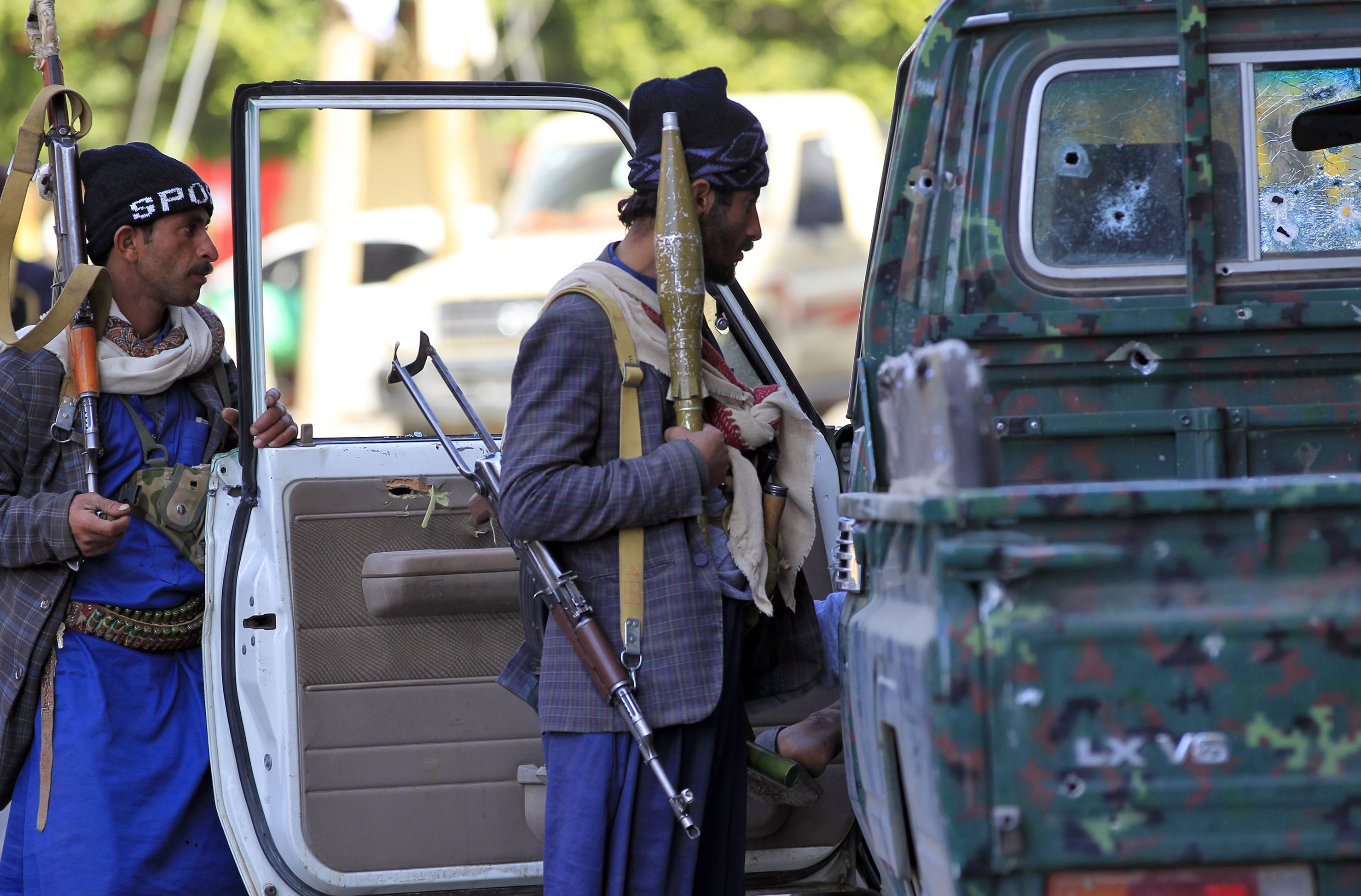 مسلحو الحوثى بجوار سيارة أصابها رصاص جراء الاشتباكات
