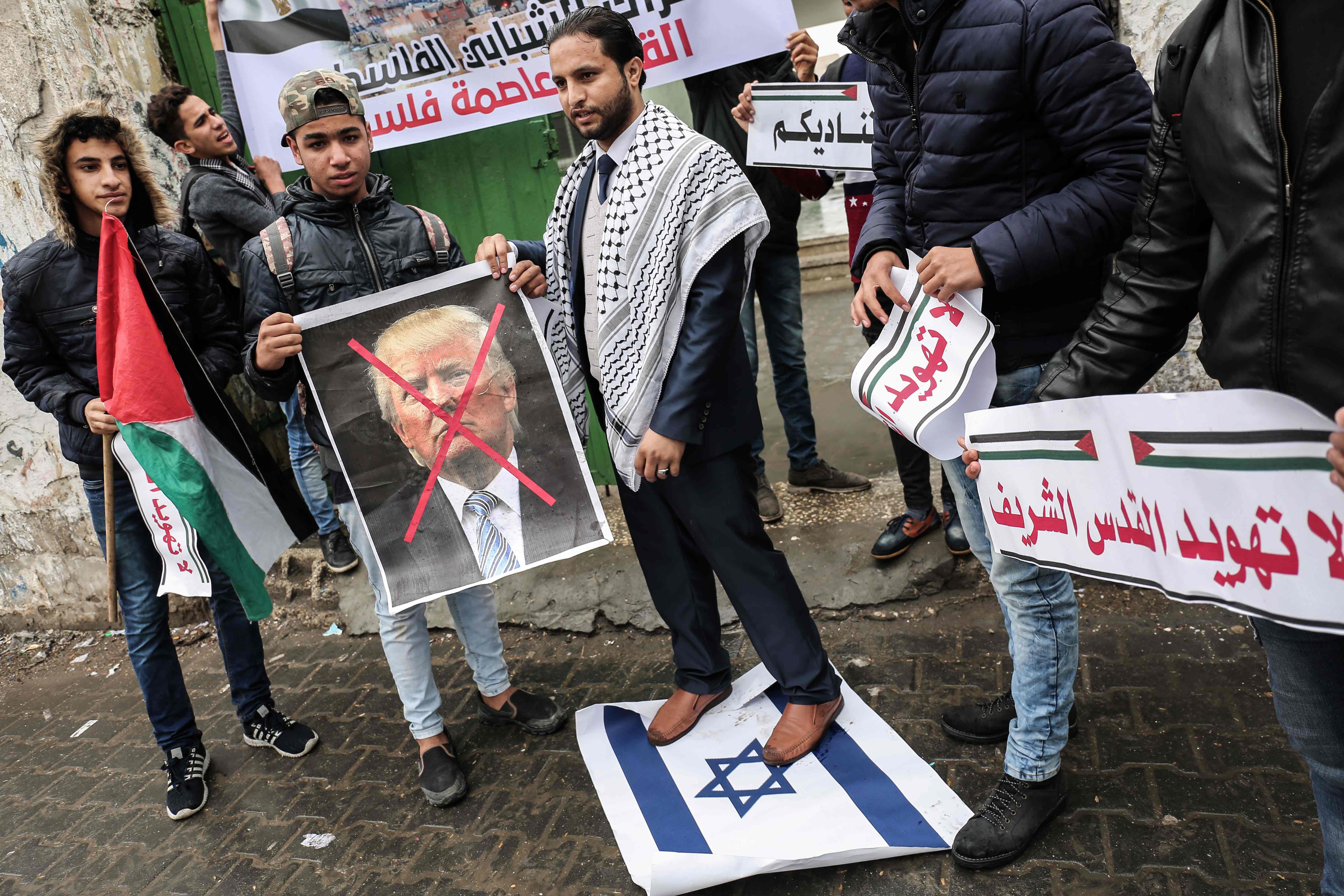 متظاهر يقف بقدمية على علم إسرائيل