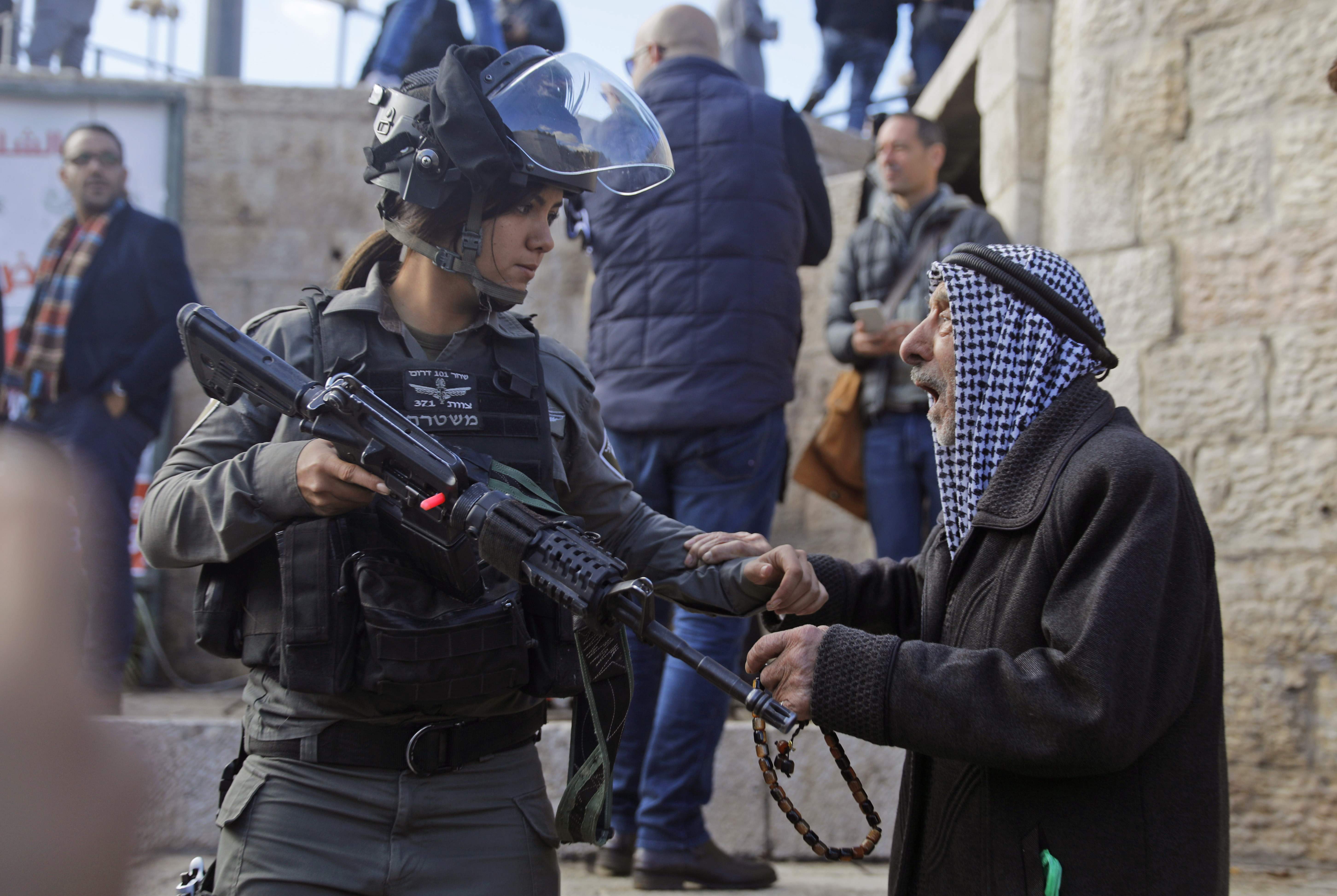 جندية اسرائيلية تشهر سلاحها على مسن فلسطينى