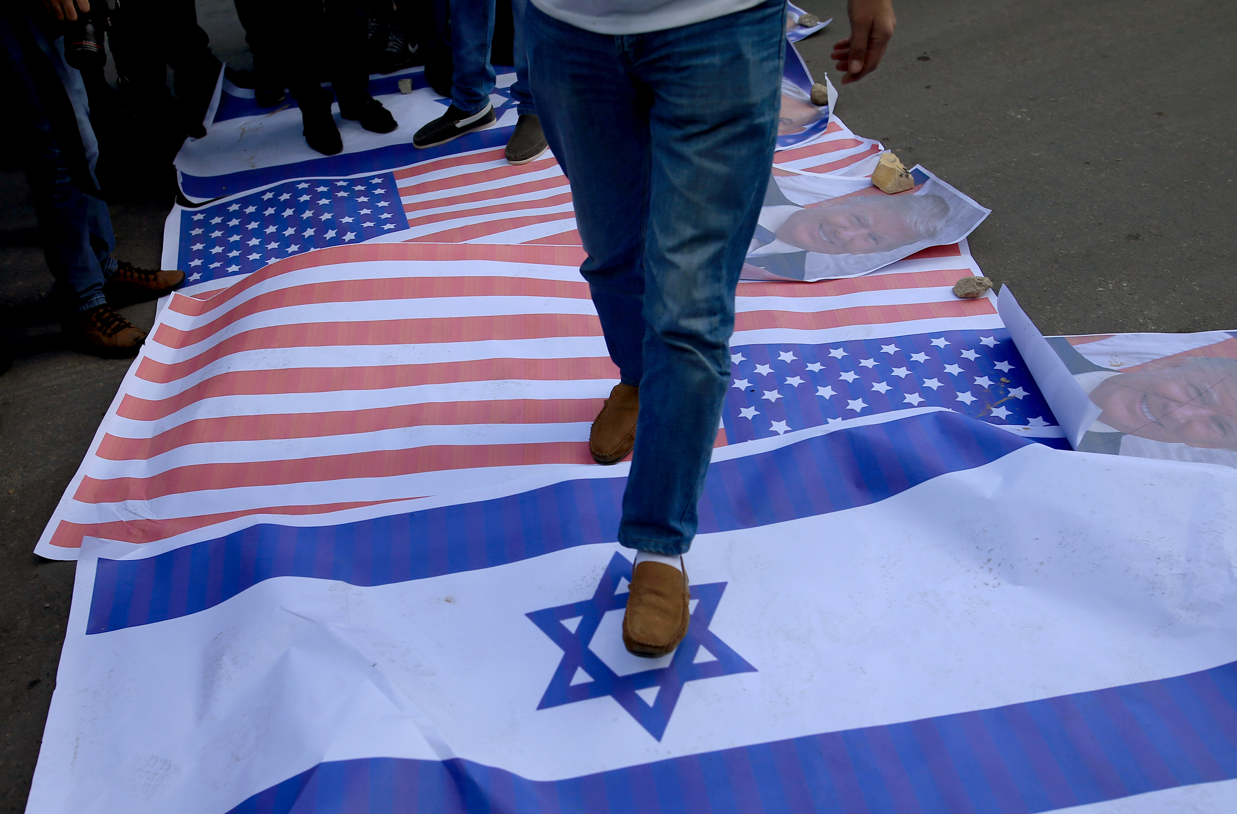 الفلسطينيون يدوسون بأقدامهم على العلم الاسرائيلى والأمر يكى