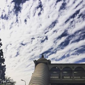 طالب يلتقط صورة لمبنى جامعة القارئ مع السحاب