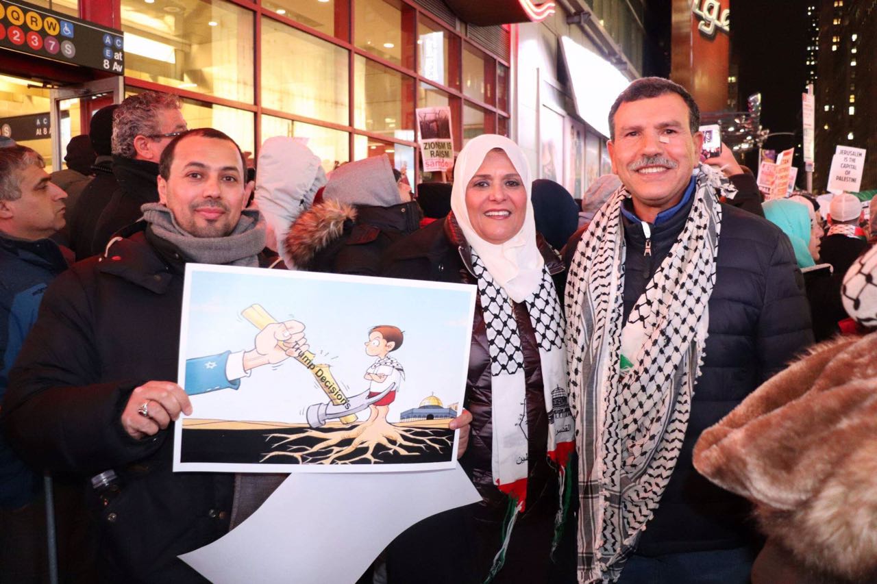 المتظاهرون يرفعون كاريكاتير يصور ترامب يغتال أطفال فلسطين