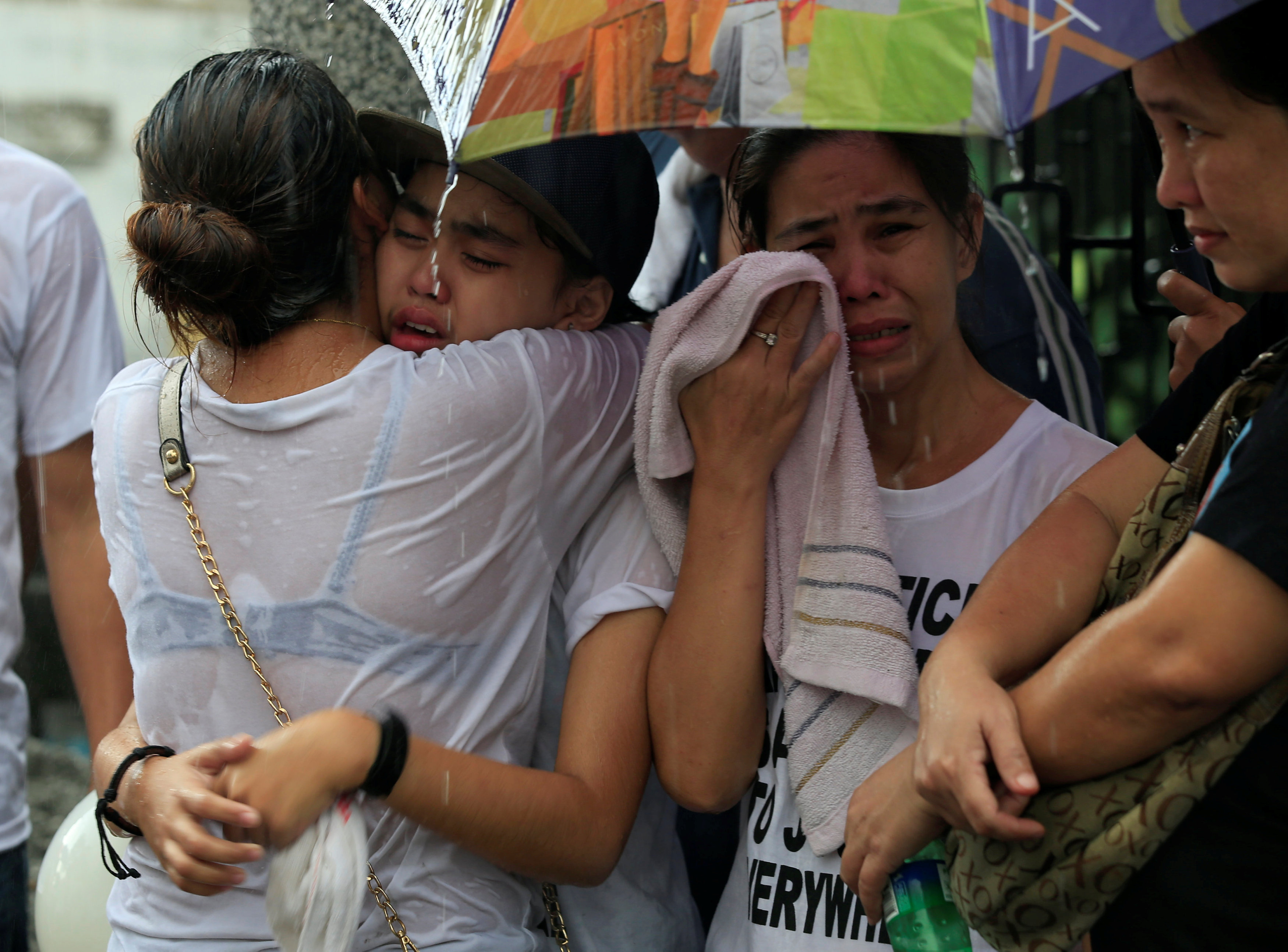 أصدقاء الشاب الفلبينى المقتول يواسون بعضهم خلال جنازته
