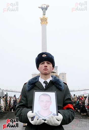 جندى أوكرانى يحمل صورة زميله القتيل فى الحرب شرق أوكرانيا