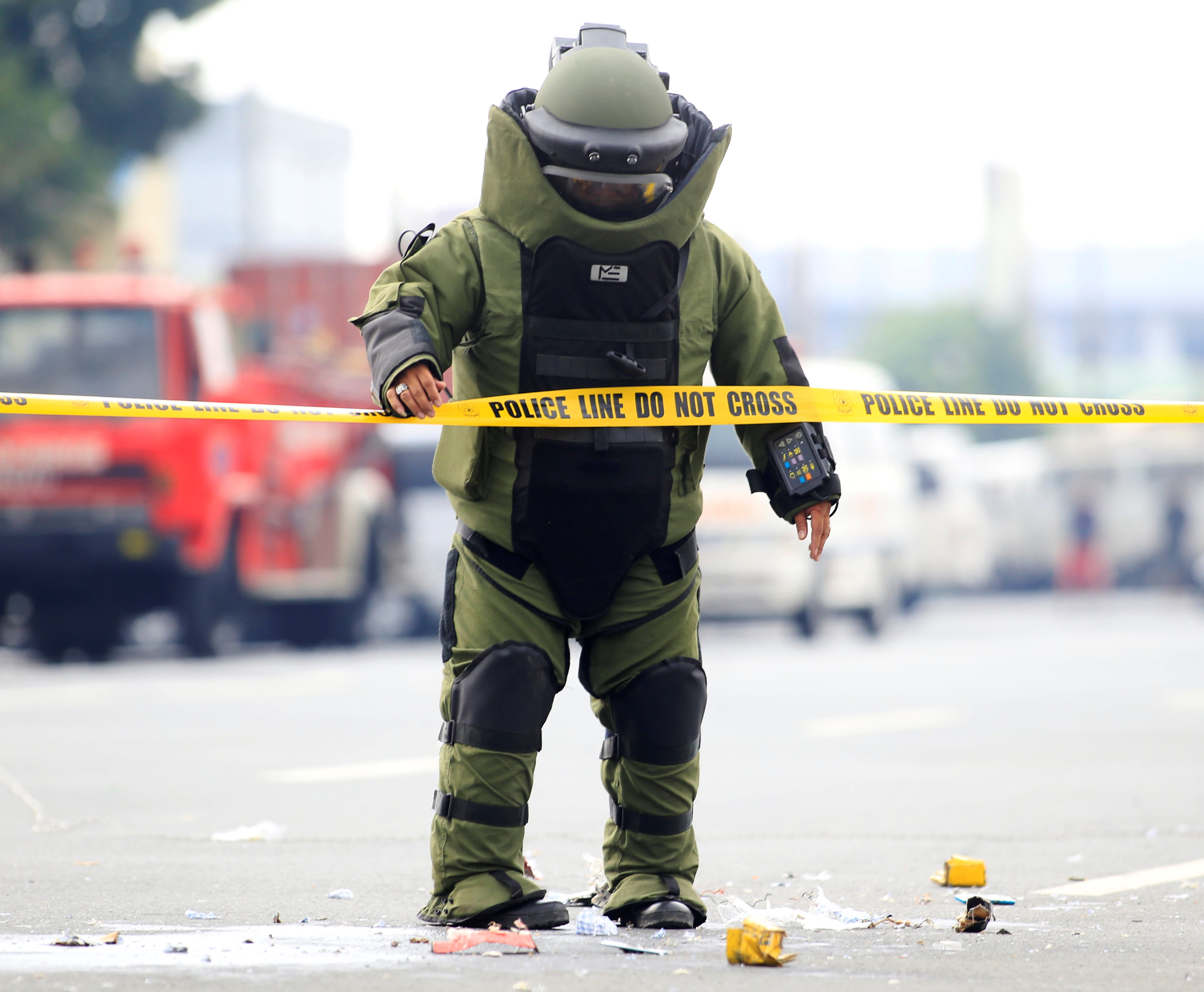 ضابط المفرقعات يقف بجانب أثار العبوة الناسفة بعد تفجيرها