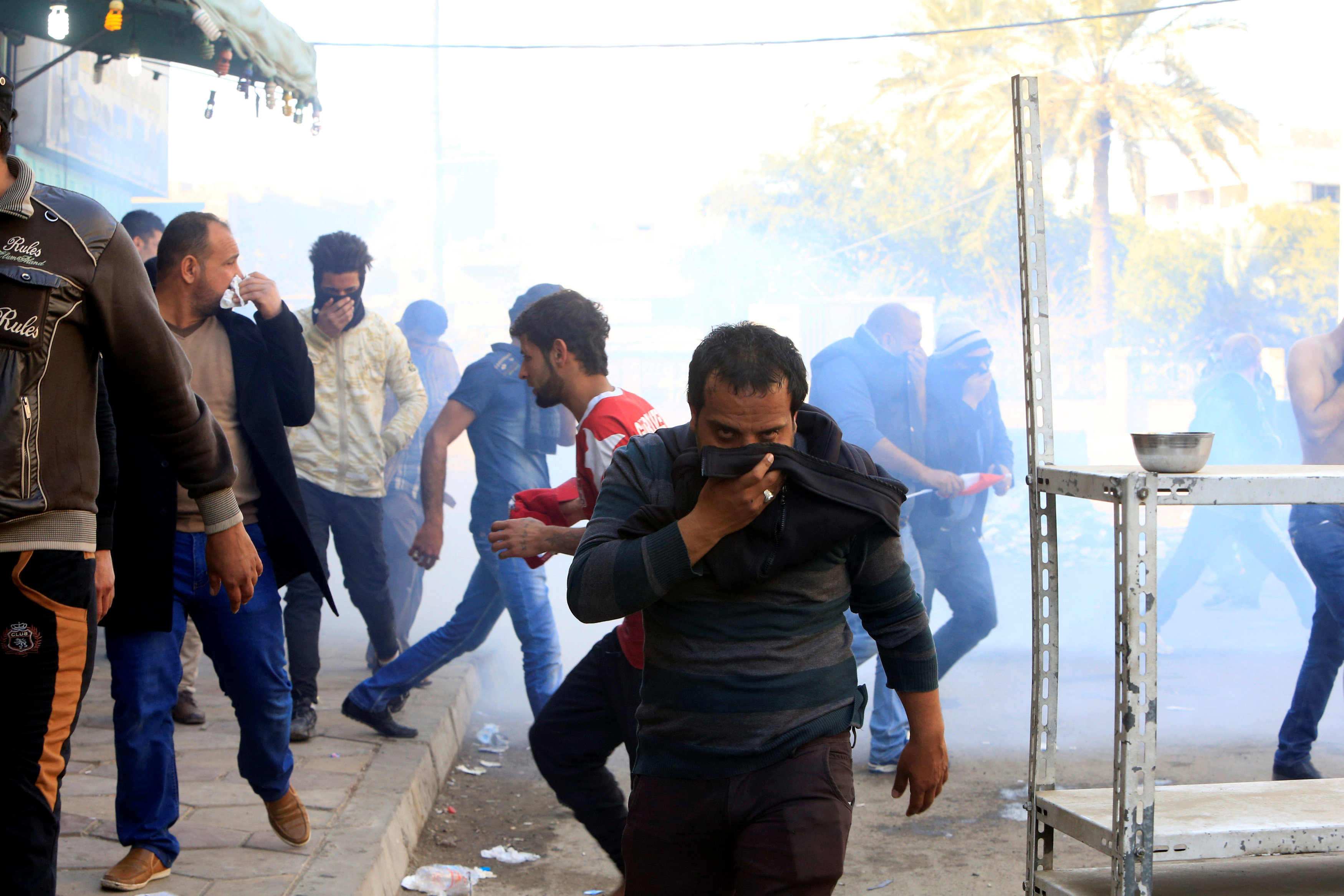 متظاهرو التيار الصدرى يحمون وجوههم من غاز القنابل المسيلة للدموع فى مواجهة مع الشرطة
