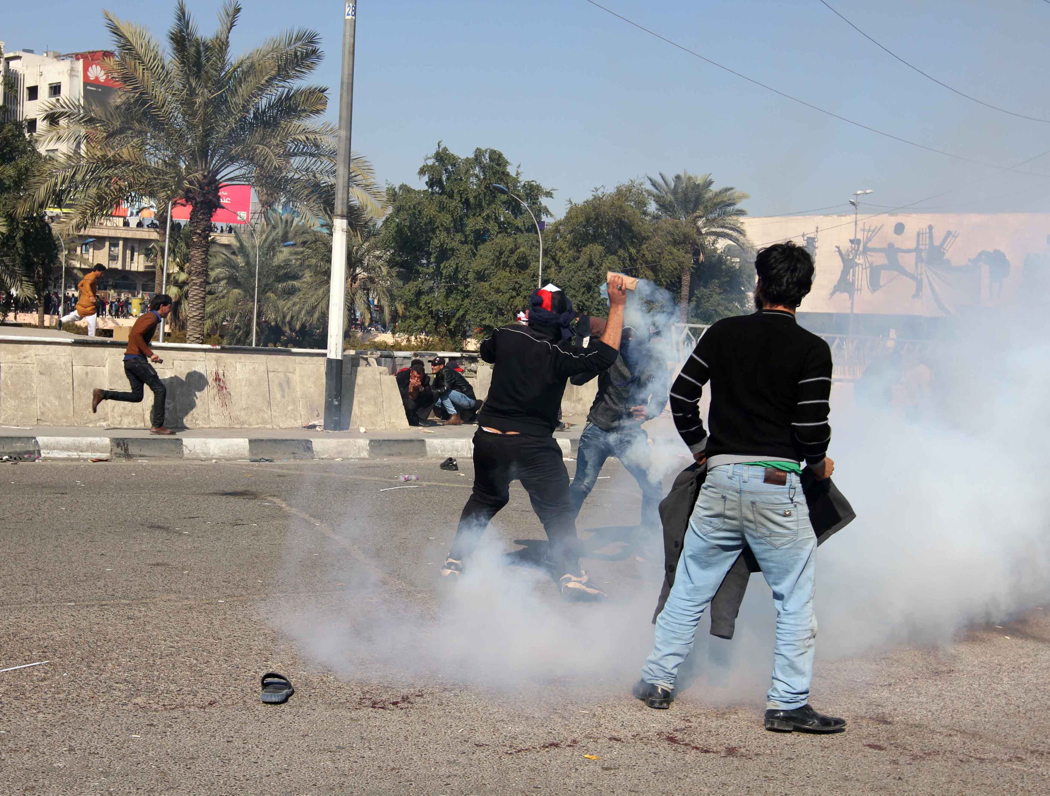 دخان قنابل الغاز المسيل للدموع يصيب أحد المتظاهرين فى بغداد