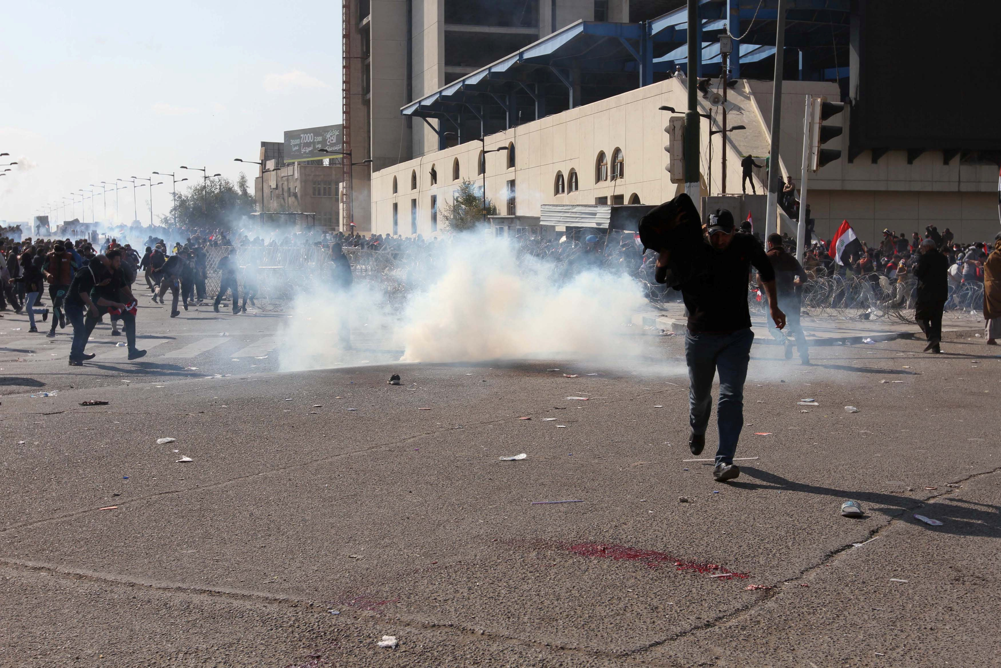 دخان قنابل الغاز المسيل للدموع يملأ ساحة التحرير فى بغداد