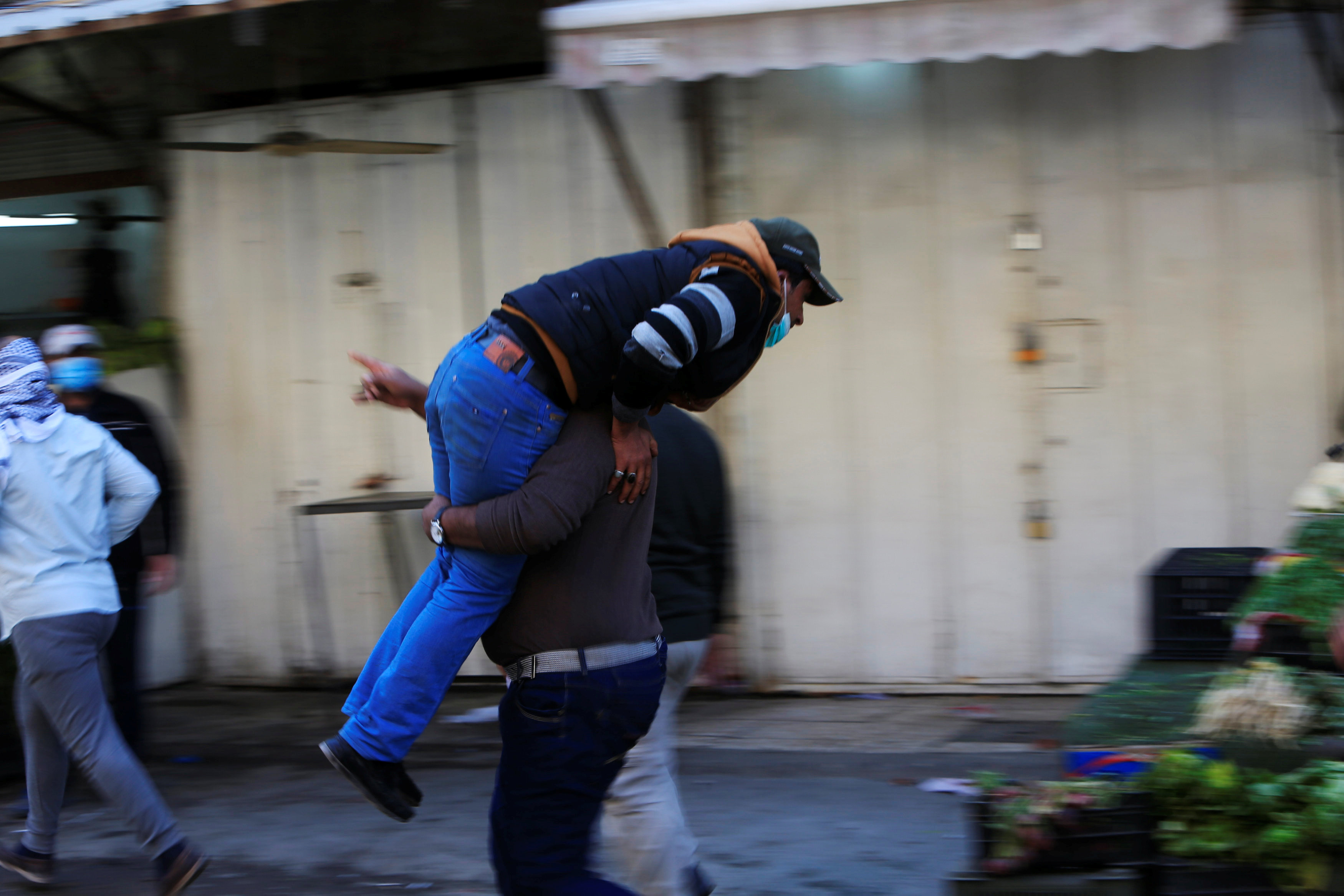 متظاهر يحمل مصاب خلال مواجهات مع الشرطة العراقية فى ساحة التحرير
