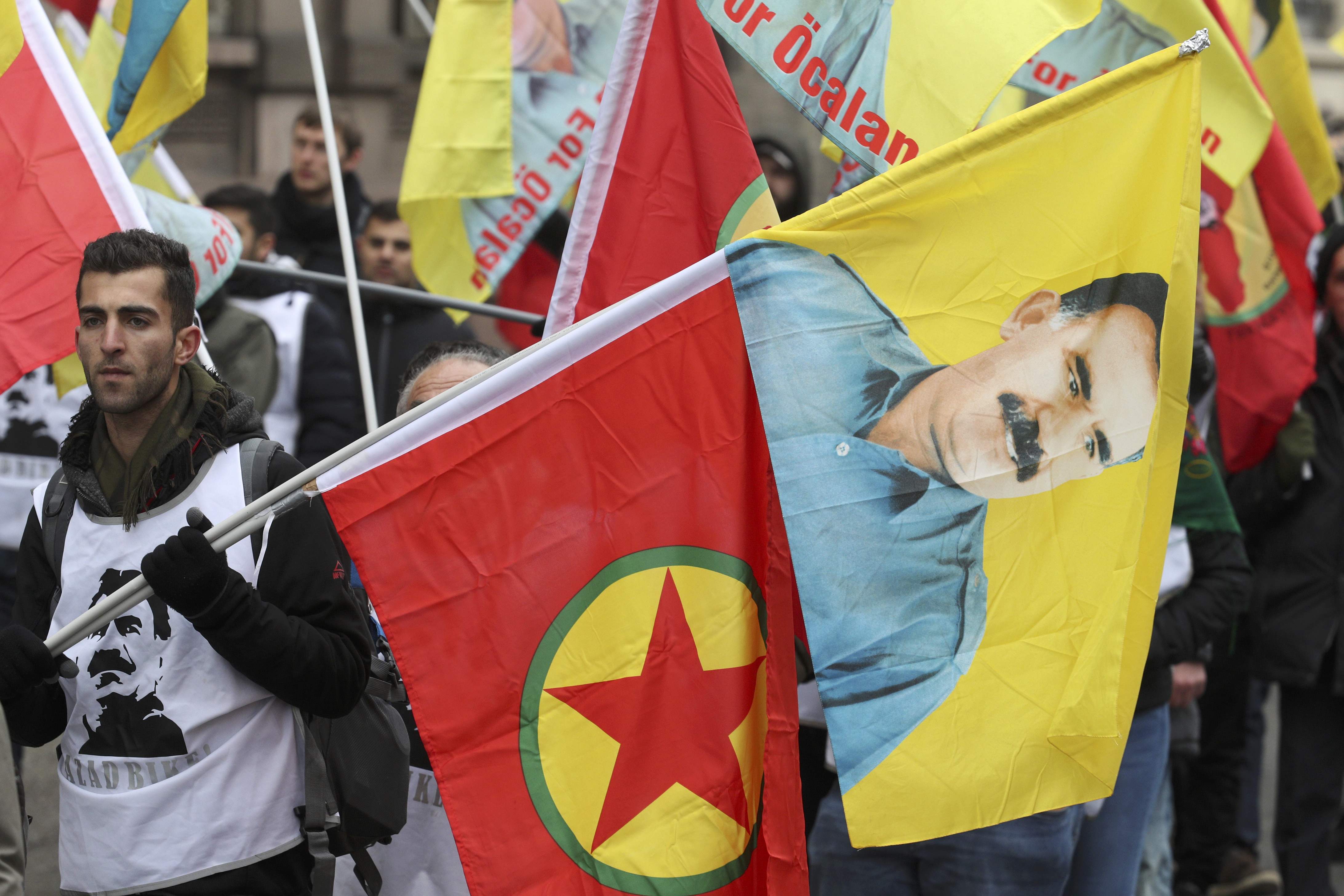 متظاهر يحمل صورة زعيم حزب العمال الكردستانى وشعار الحزب