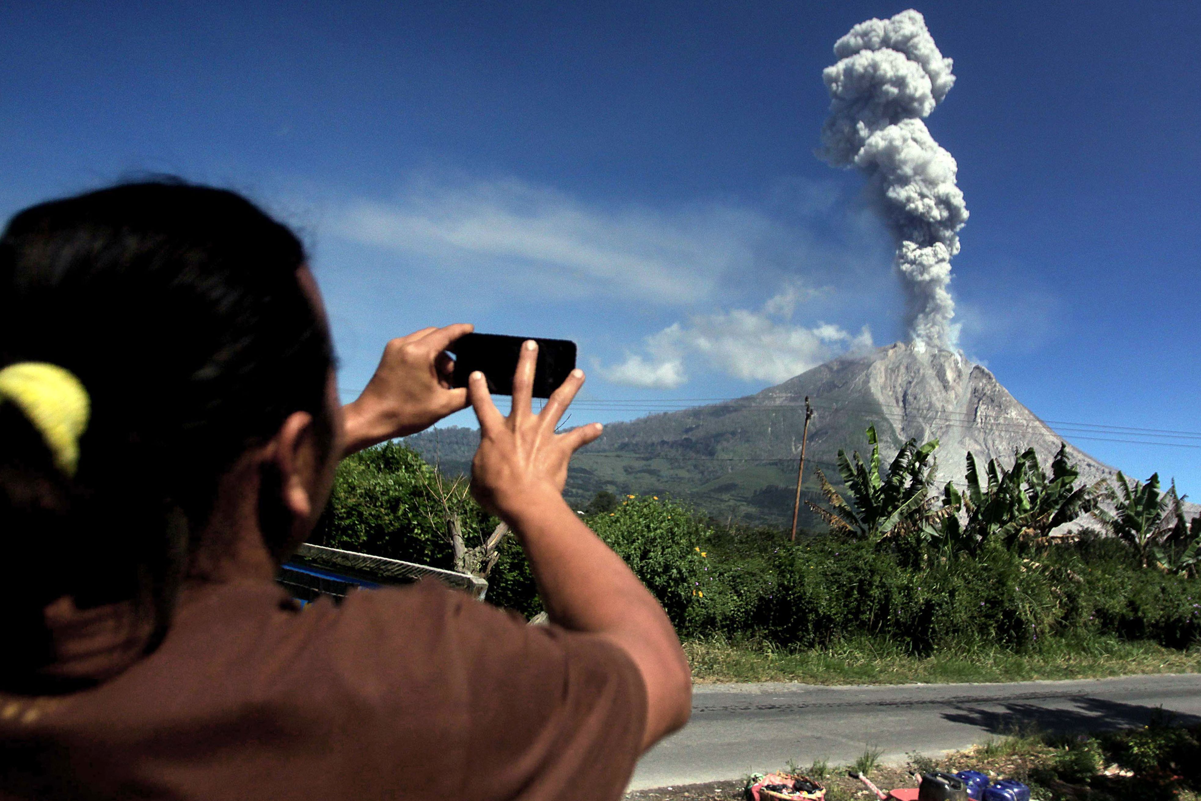 مواطنة تلتقط صور لنشاط البركان