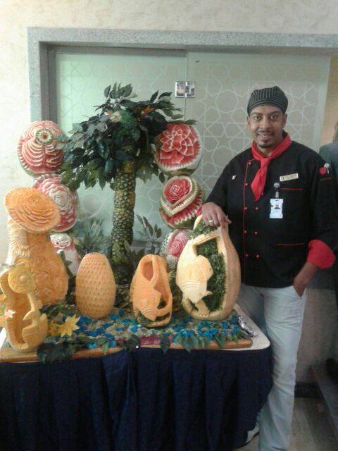 الشيف ياسر مع أعماله الفنية من الخضروات والفاكهة