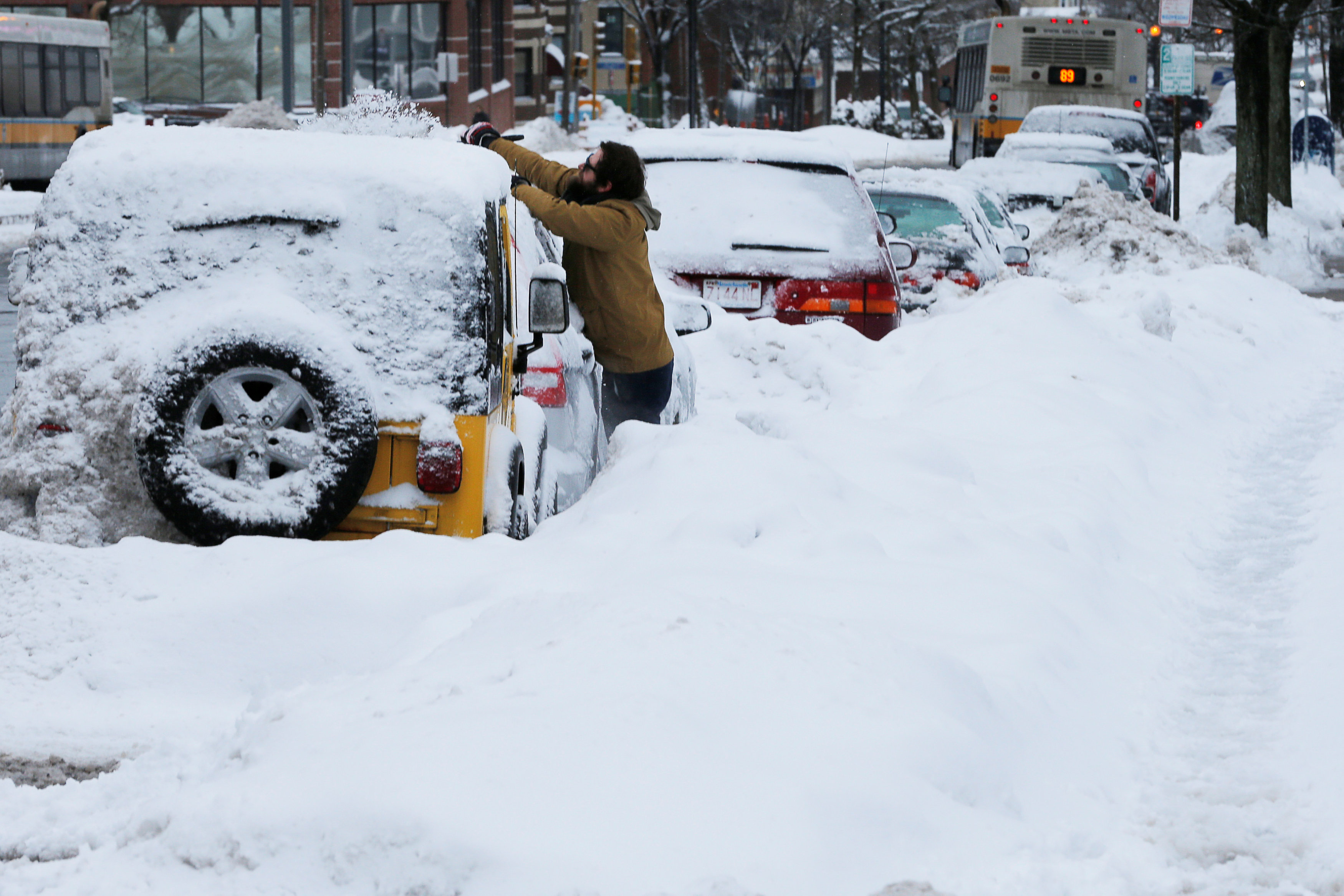 محاولات لإزالة الثلوج من السيارات