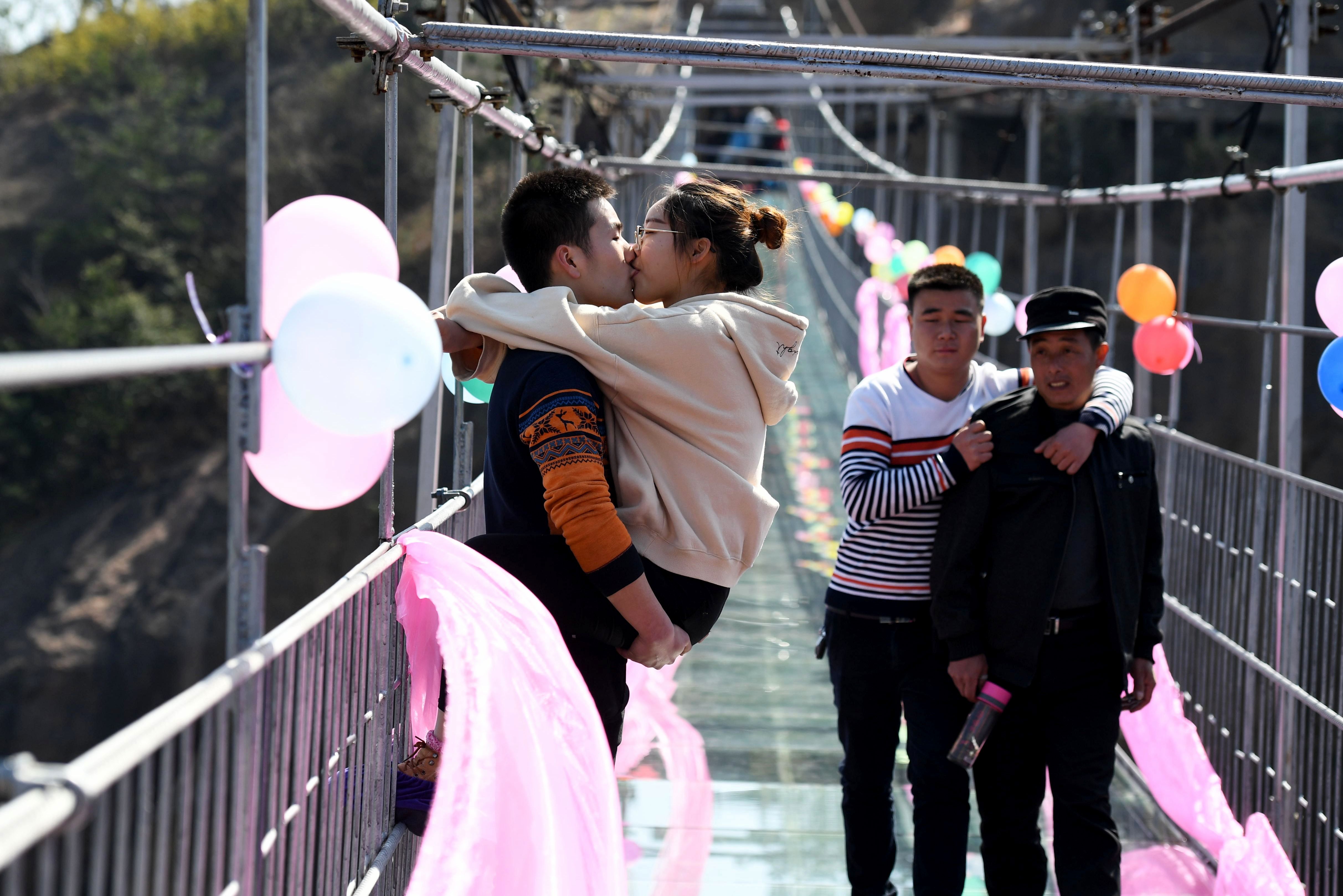شاب يقبل حبيبته على جسر بالصين فى مسابقة بعيد الحب