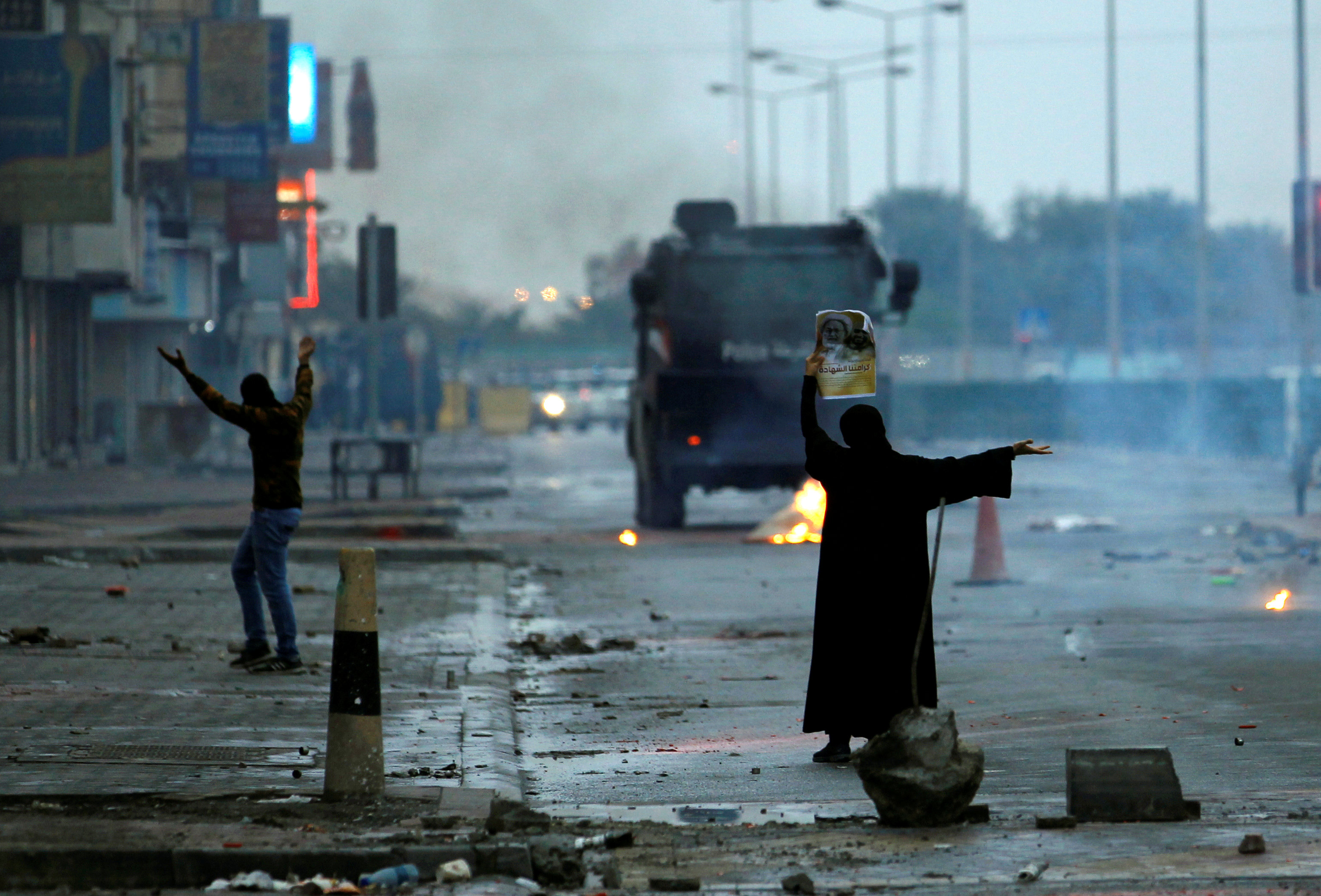 فتاة بحرينية تقف أمام رجال الشرطة خلال التظاهرات