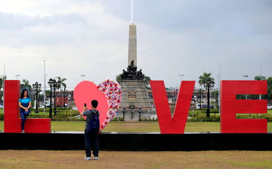 شاب يصور حبيبته فى الفلبين احتفاًلا بعيد الحب وبجانبها كلمة "حب"