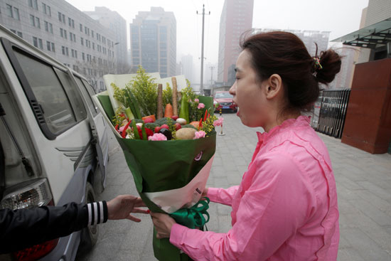 سيدة تبدى اعجابها فور تلقيها باقة ورد وخضراوات فى الصين