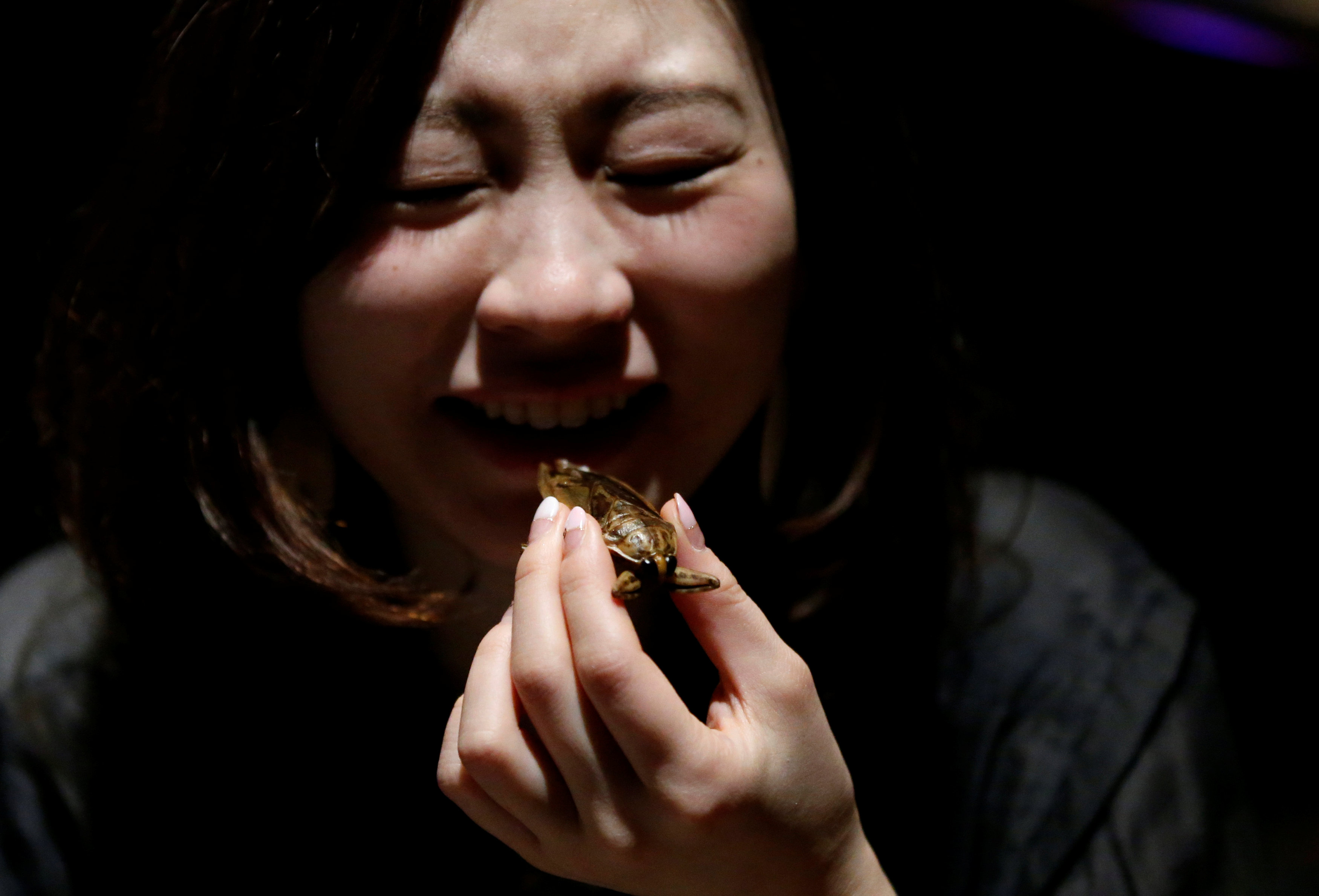 فتاة تأكل حشرة بق المياه فى احتفالات عيد الحب باليابان