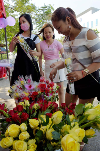 فتيات يشترين الورود الصفراء فى عيد الحب بسنغافورة