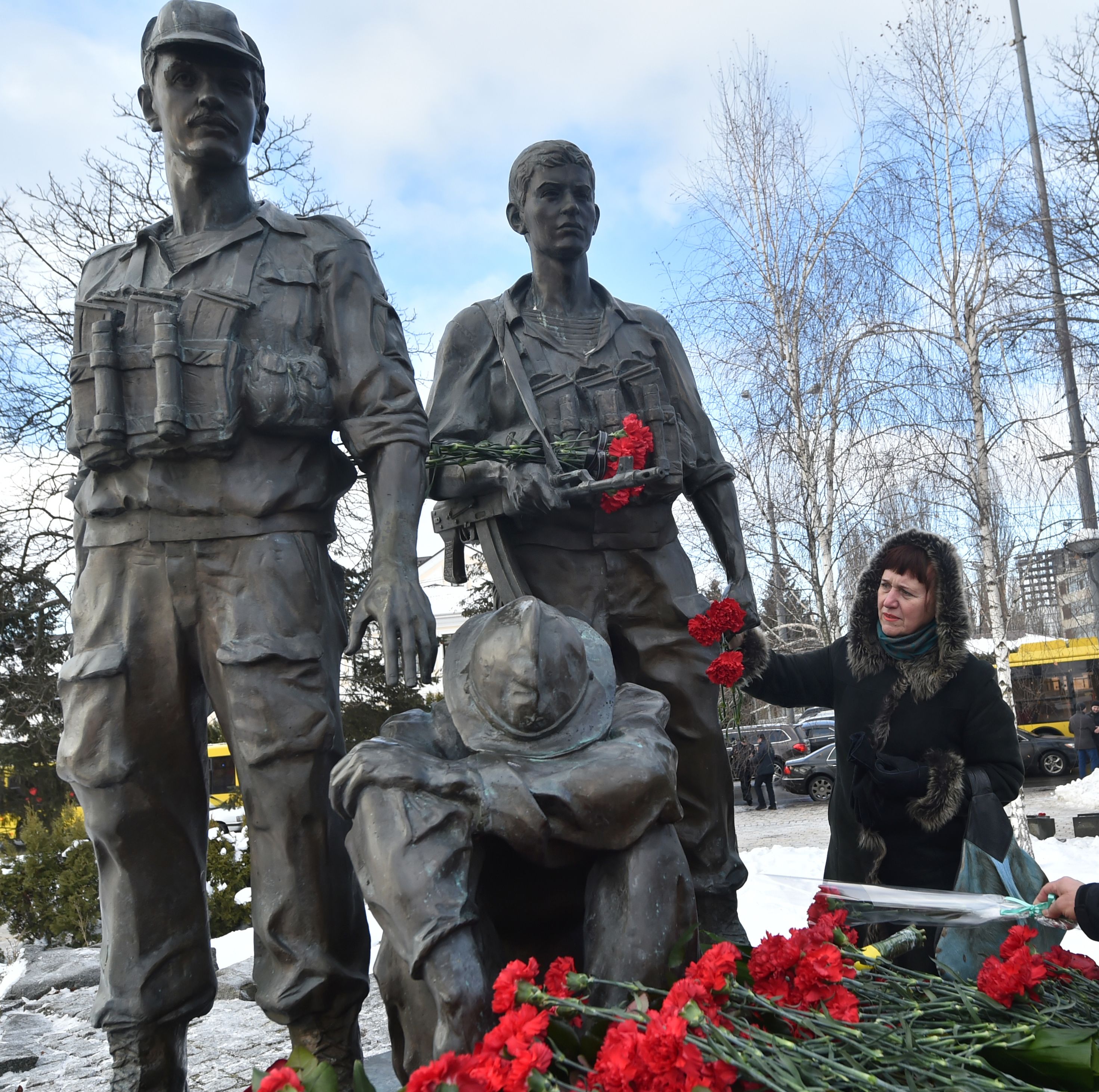 سيدة تضع ورد على تمثال بالنصب التذكارى لضحايا الحرب السوفيتية