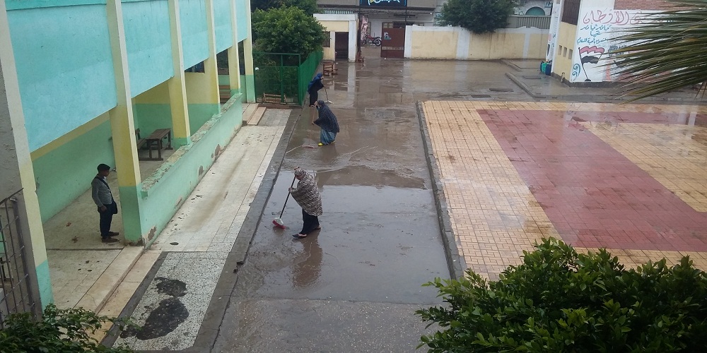 عاملات ينزحن مياه المطر