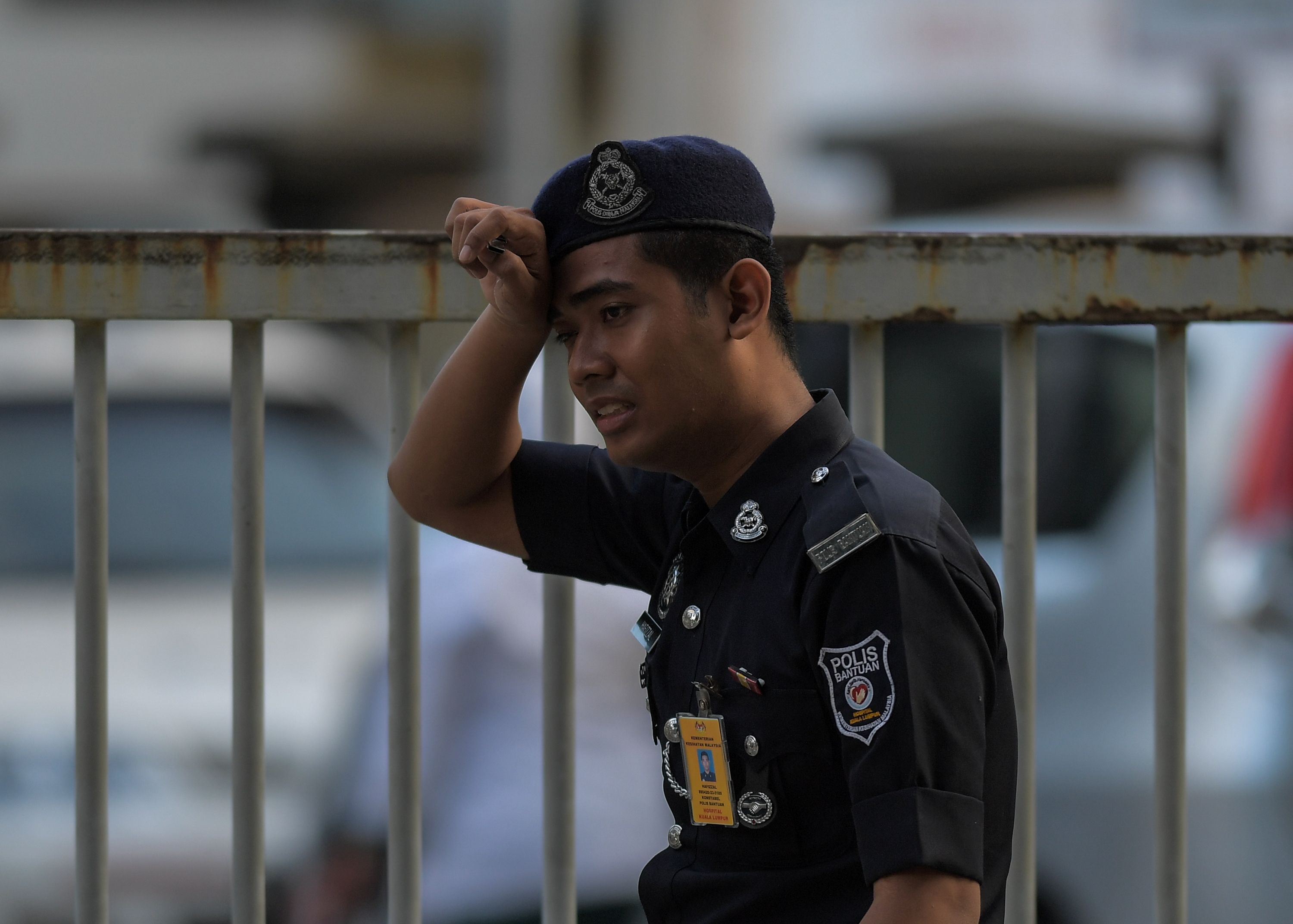 أحد أفراد الأمن الماليزى يقف أمام مستشفى الطب الشرعى