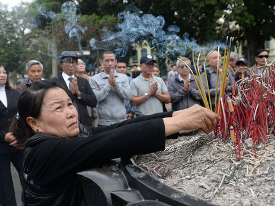 سيدة تضع البخور أمام تمثال الملك لى فى فيتنام بذكرى حرب الحدود الصينية
