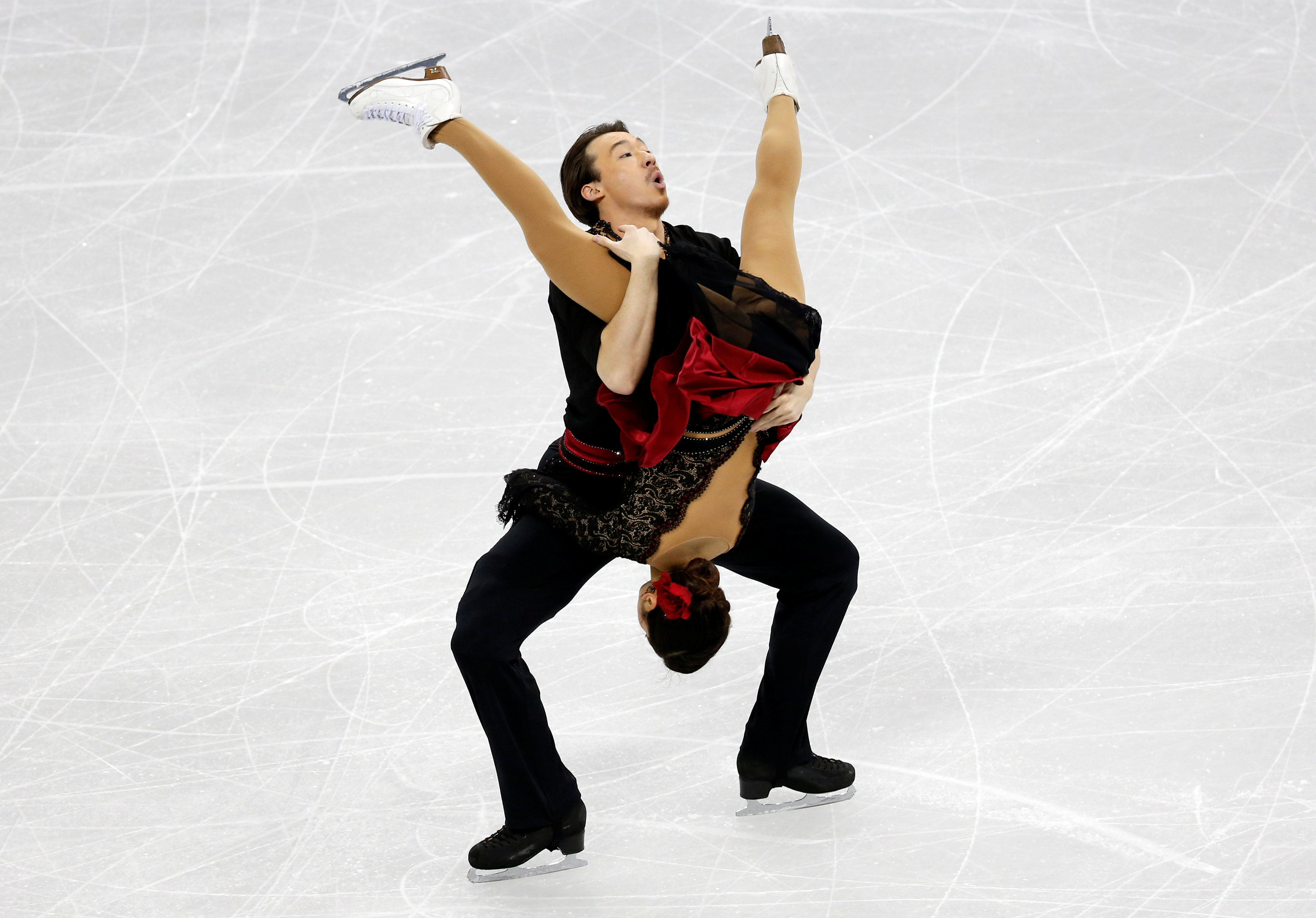 شاب يحمل شريكته فى الرقص على الجليد ويميل رأسها تجاه الأرض