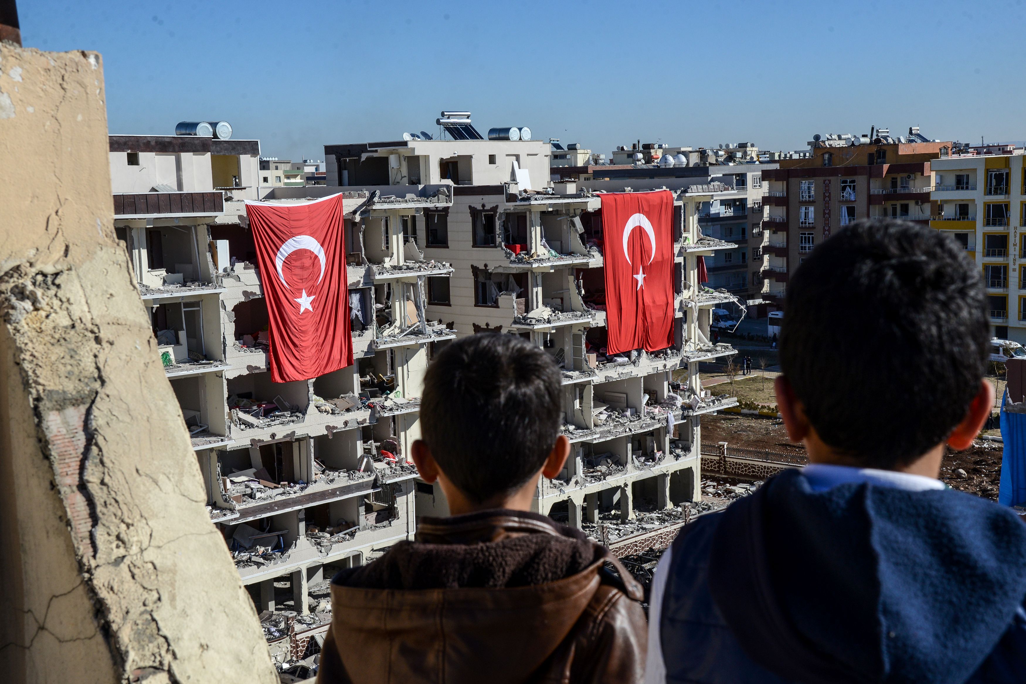 أطفال يتابعون أثار الدمار فى بلدة تركية نتيجة انفجار