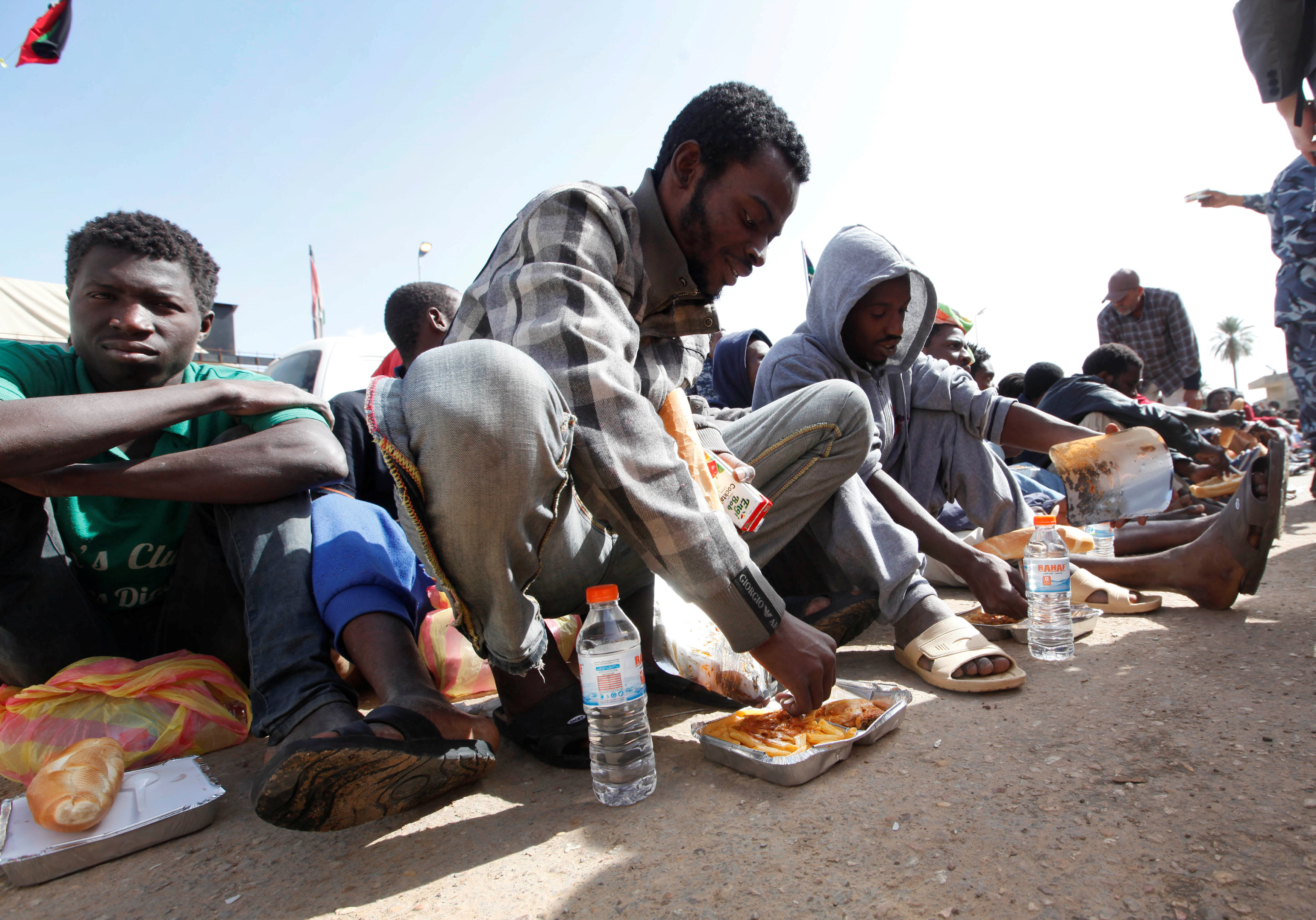 مهاجرون يتناولون الطعام