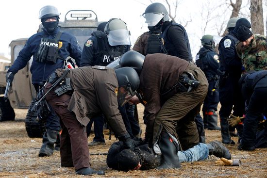 قوات الأمن تلقى القبض على أحد المتظاهرين