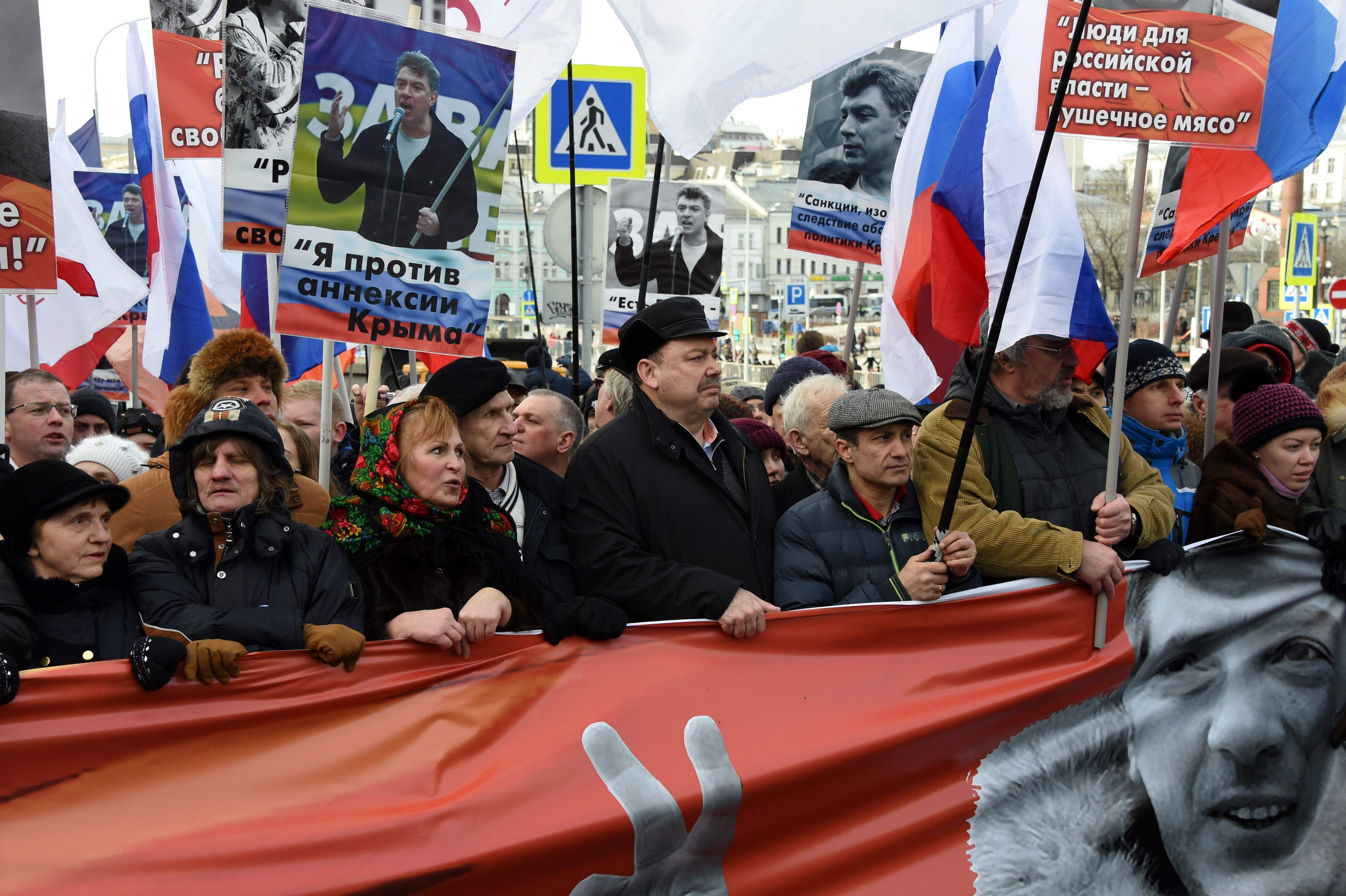 متظاهرون يحملون لافتات وصور المعارض المعارض الروسى بوريس نيمتسوف فى ذكرى اغتياله الثانية