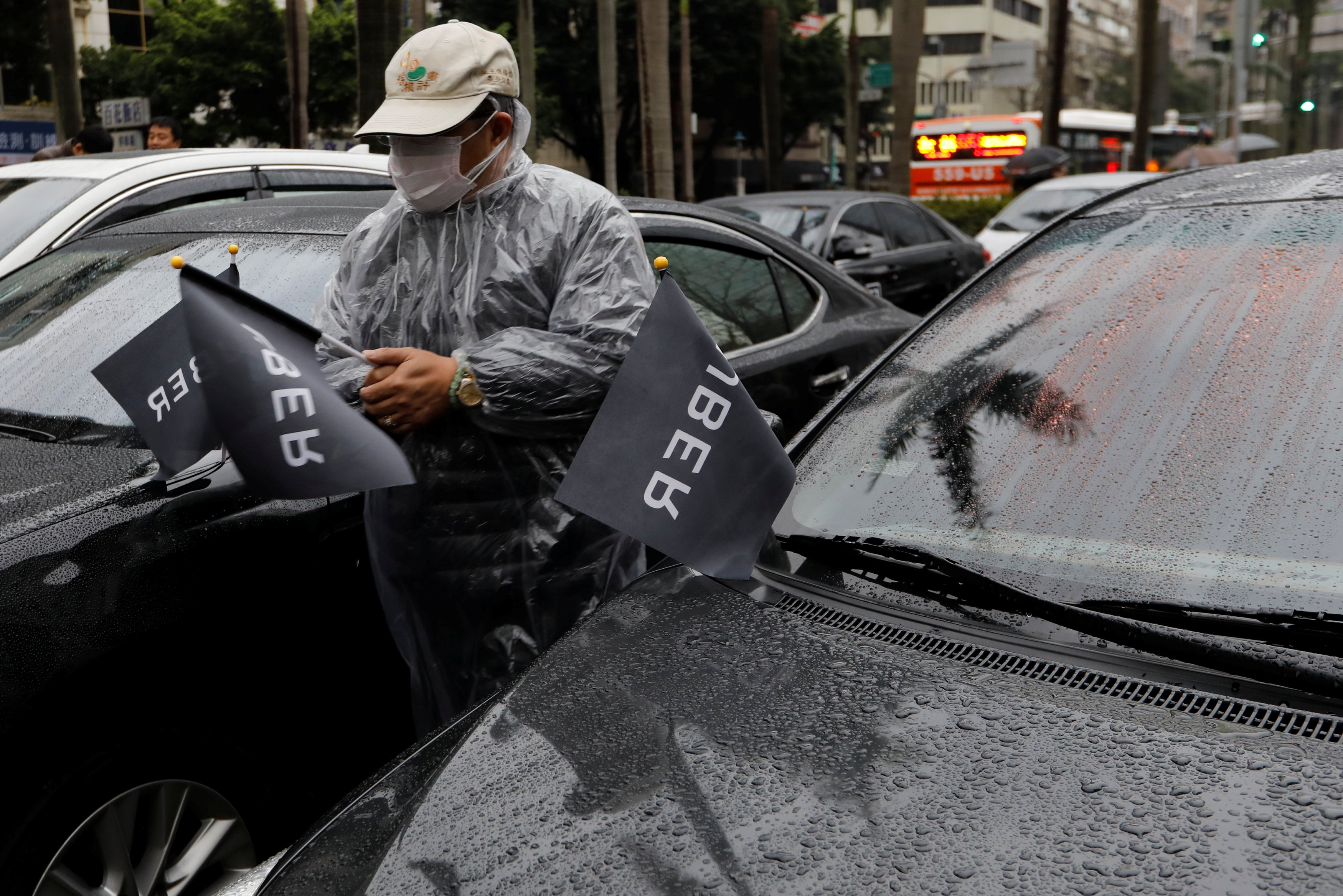 سائق أوبر يعلق أعلام بشعار الشركة على السيارات خلال المظاهرة فى تايوان