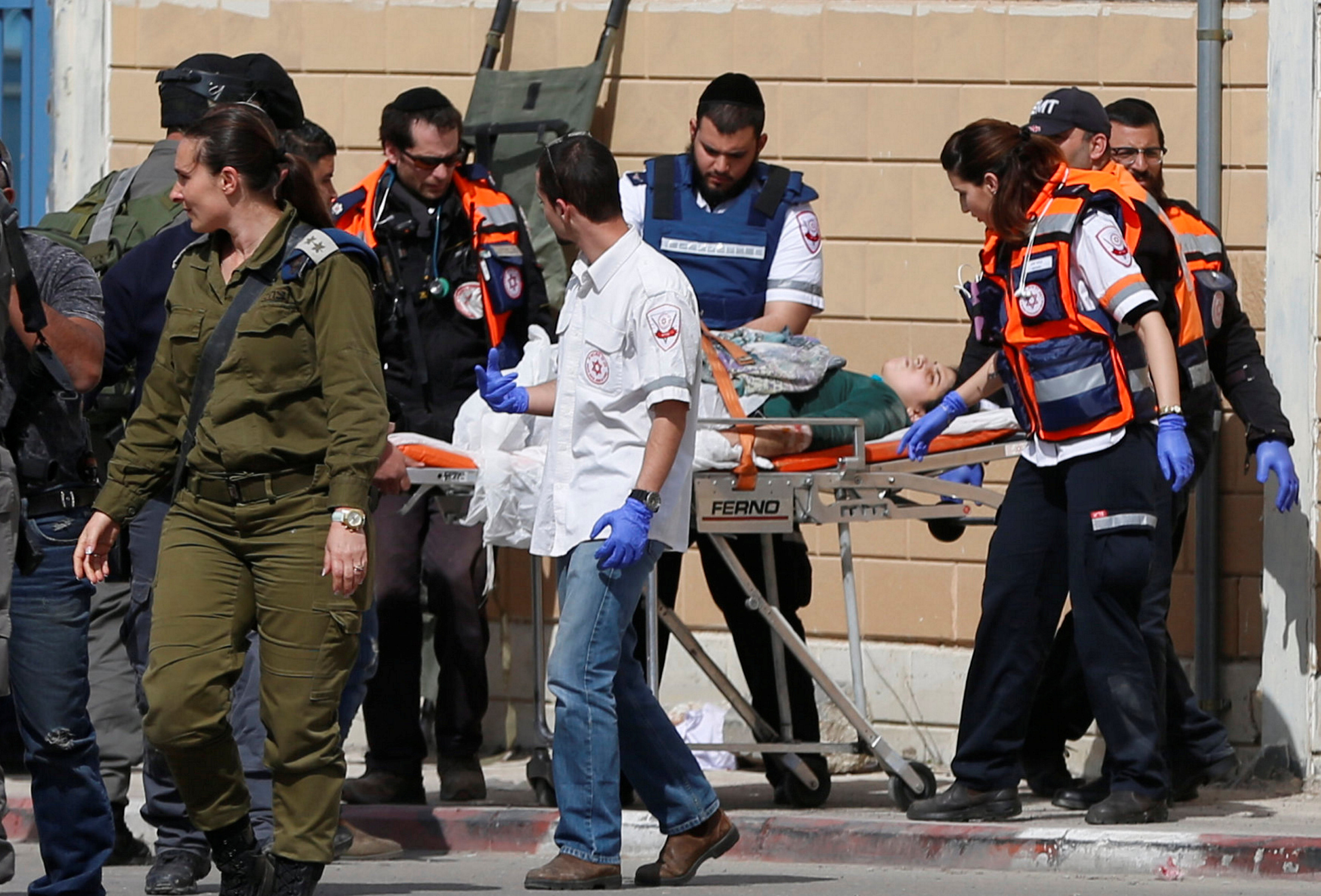 مسعفون ينقلون فتاة فلسطينية اصابتها قوات الاحتلال بالرصاص