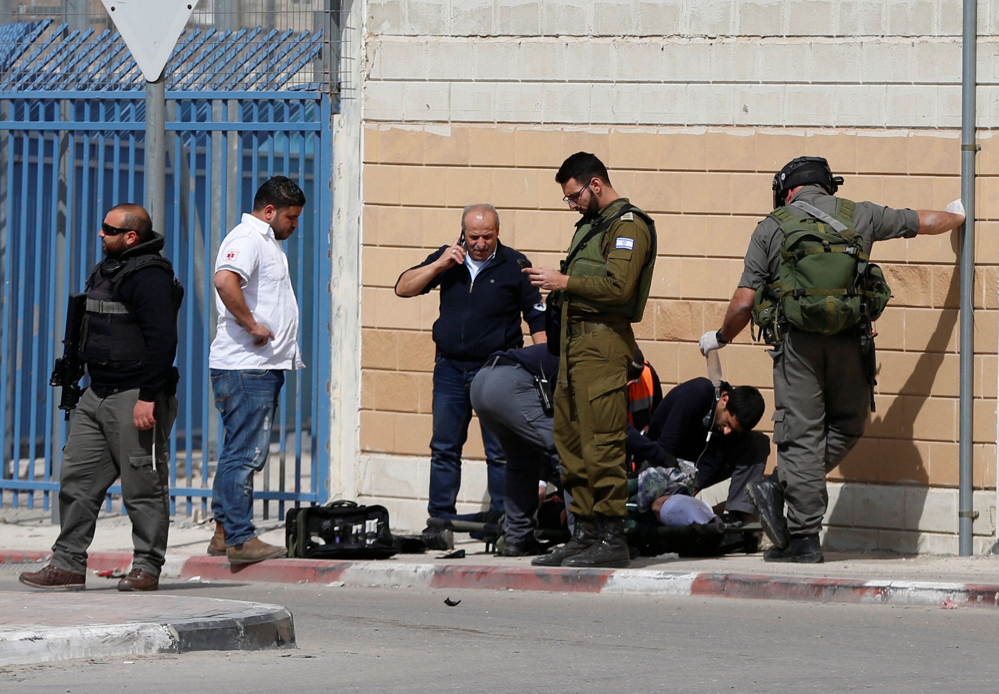 عناصر قوات الاحتلال الاسرائيلى بجوار فتاة فلسطينية اصابوها بالرصاص