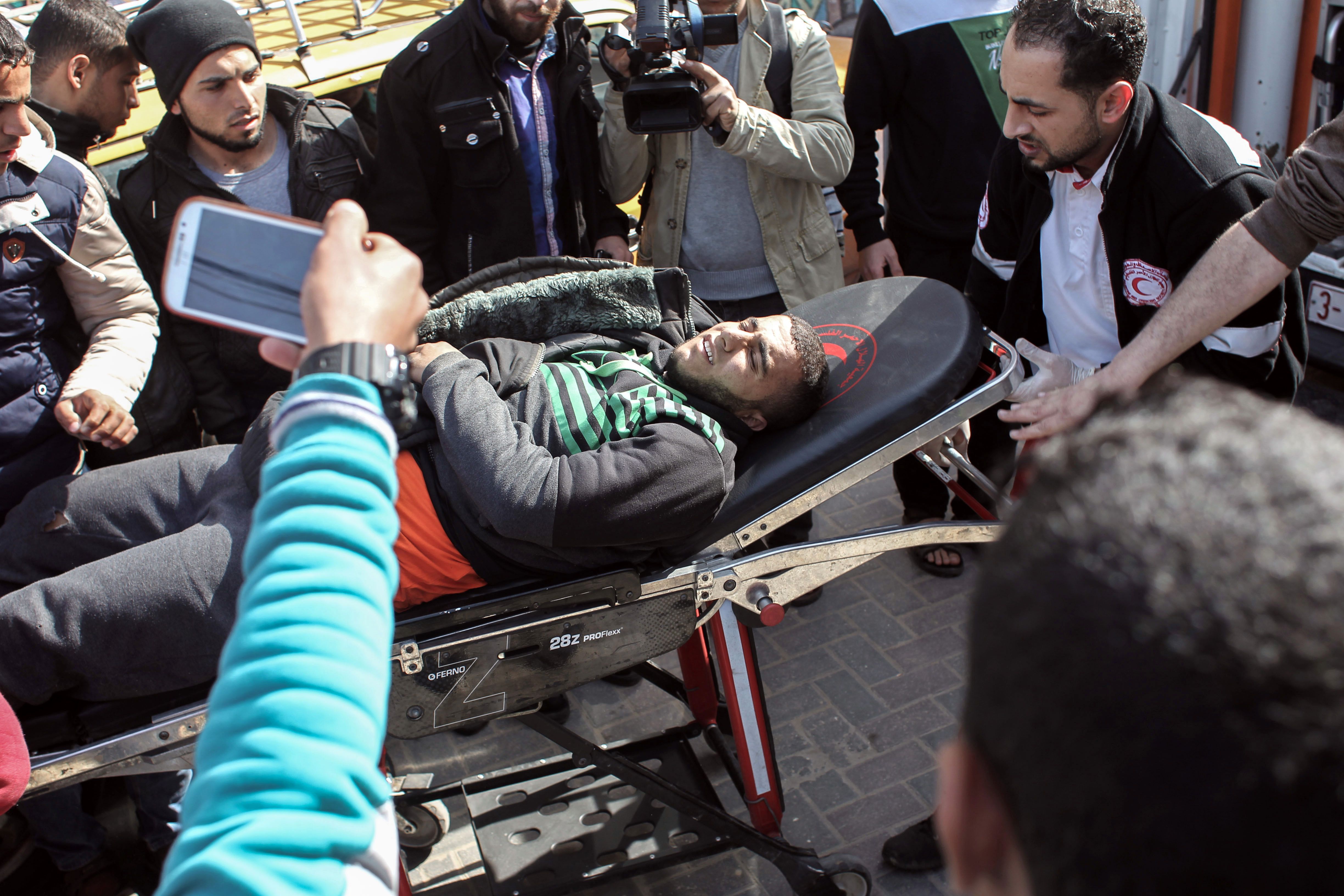 شباب يصورون المصابين الفلسطينيين أثر الغارات الجوية الإسرائيلية