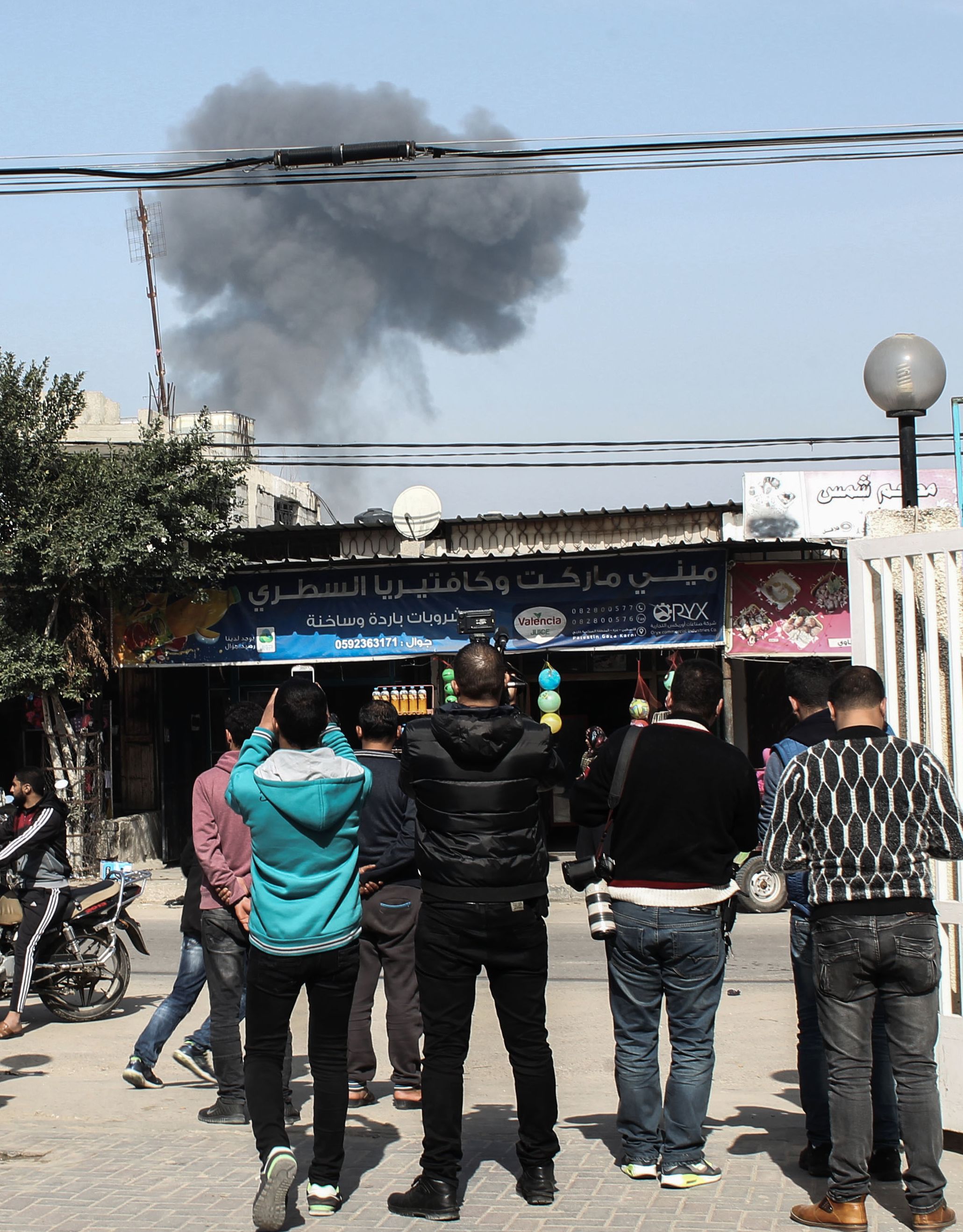 شباب فلسطينى يصورون الدخان المنبعث عن الغارة الجوية الإسرائيلية على قطاع غزة